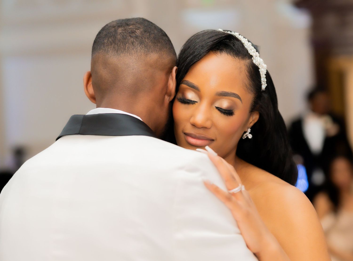 A loving couple shares an intimate dance embrace at their elegant wedding celebration.