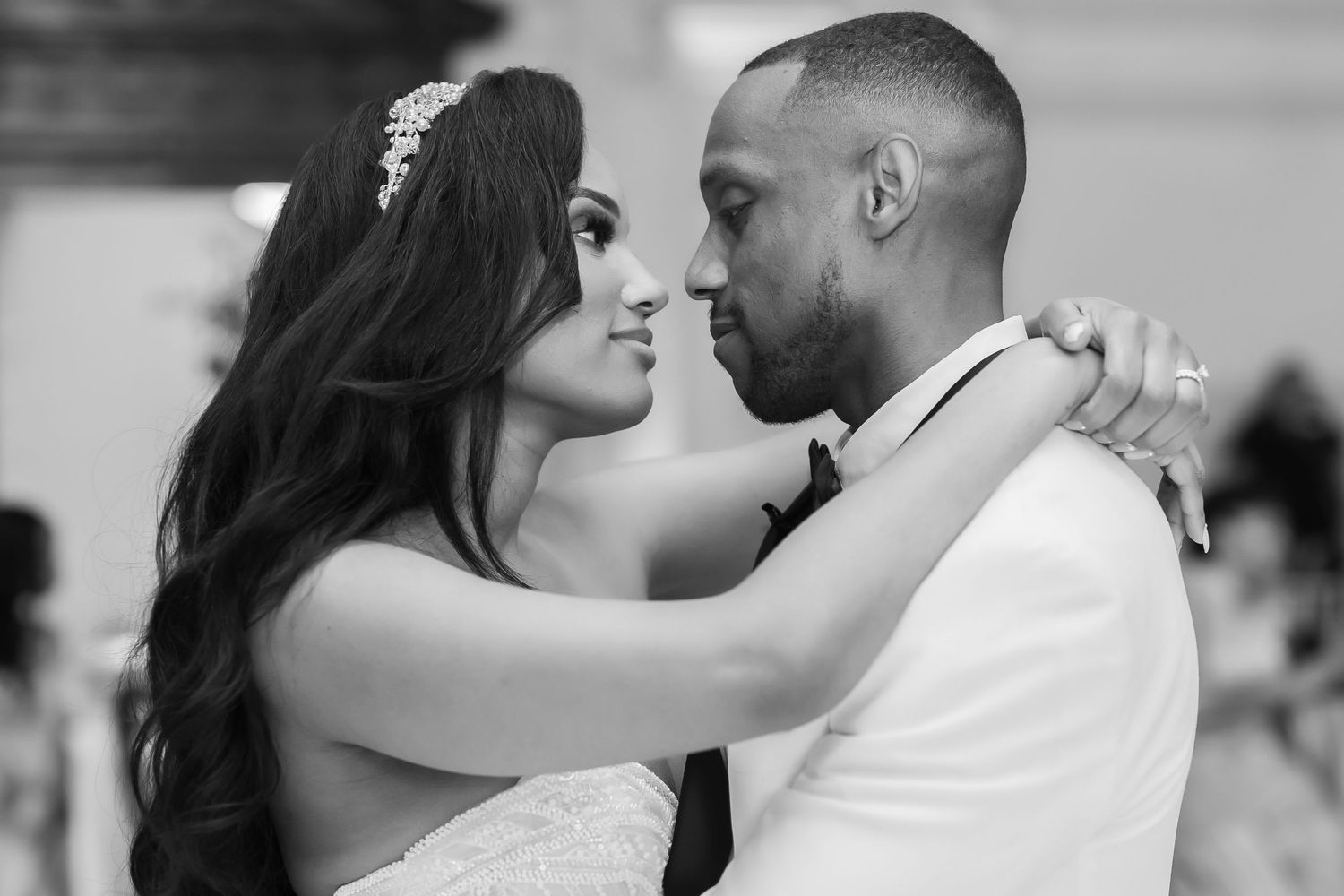 A bride and groom share an intimate moment during their wedding day in black and white photography.