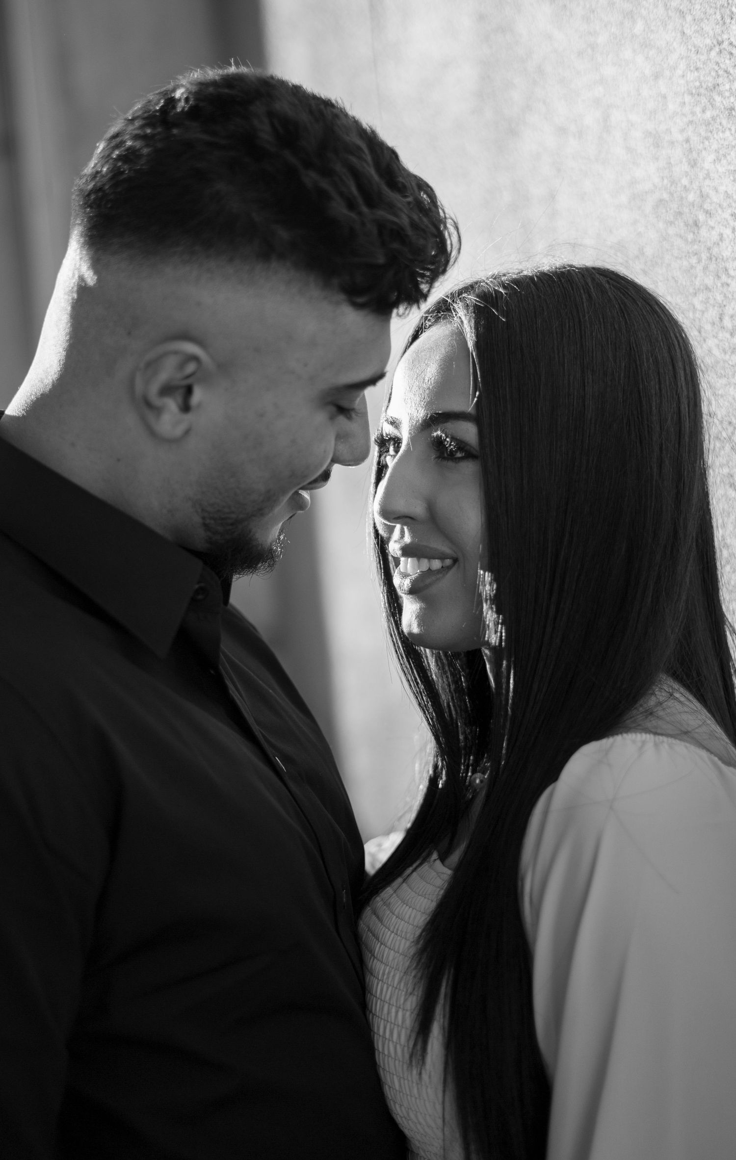 Black and white photo series showing a romantic couple in an intimate moment with dramatic lighting and shadows.