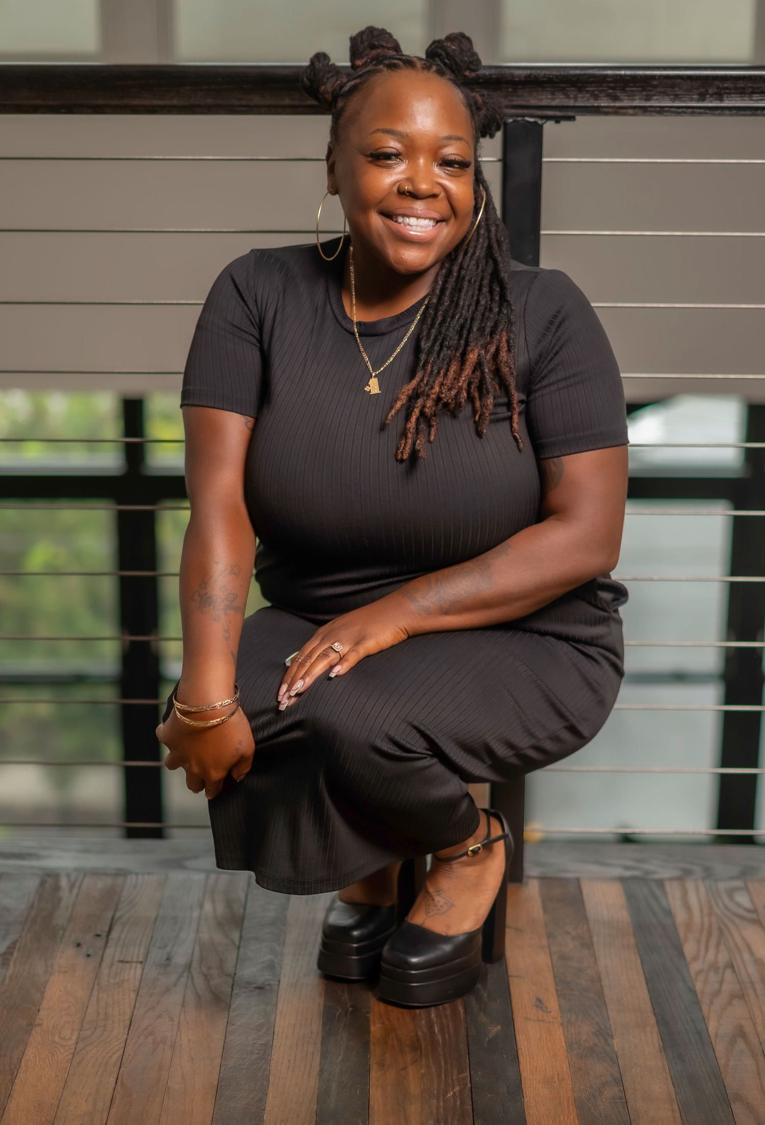 A woman in a black outfit poses confidently on a wooden floor in a series of professional portrait photos.