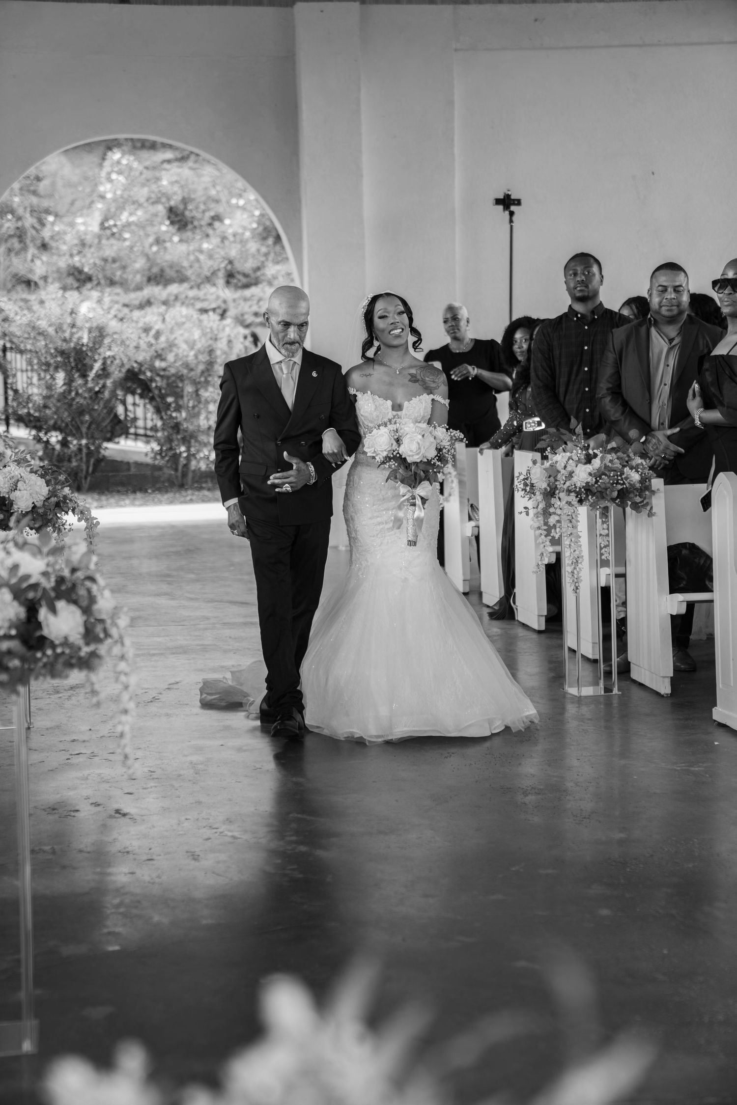 A black and white photo series showing a traditional wedding processional walking down the aisle in a church ceremony.