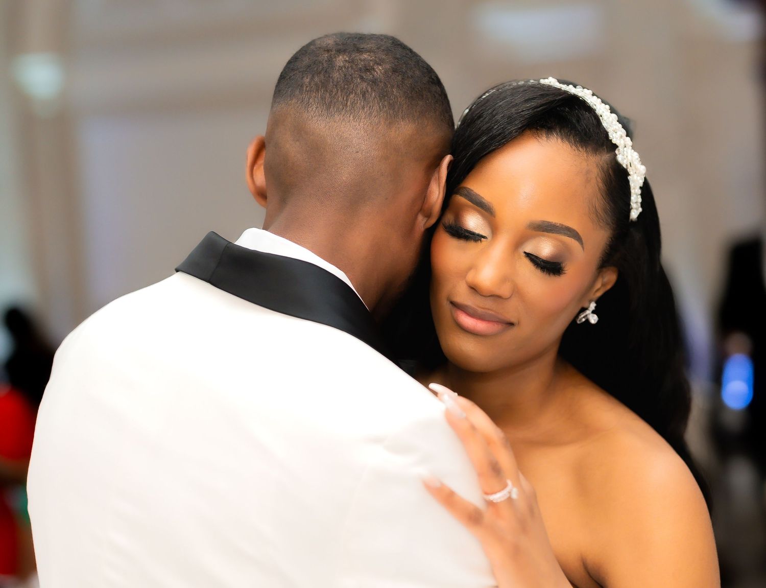 A tender moment between newlyweds sharing their first dance at an elegant wedding reception.