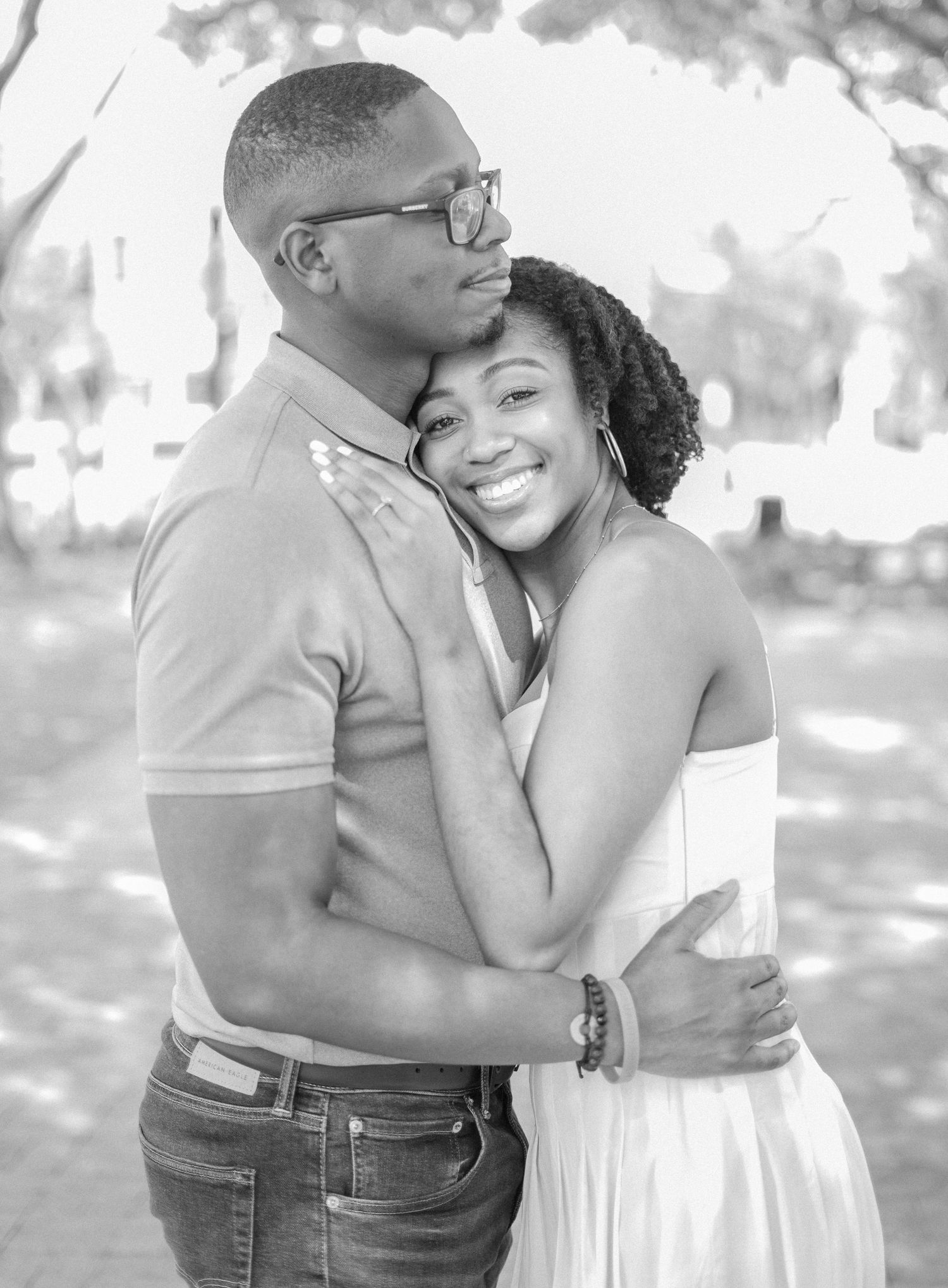 A black and white portrait of a couple in a tender embrace during their engagement session.
