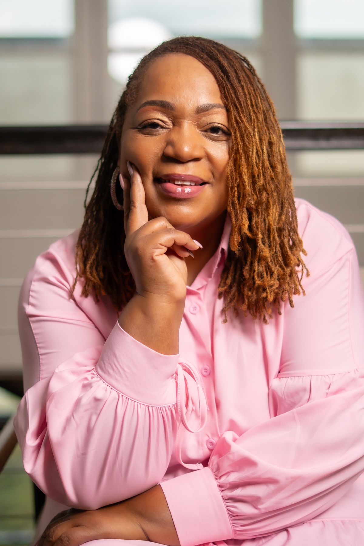 A series of expressive portraits showing someone in a pink top against a light background with changing poses and smiles.