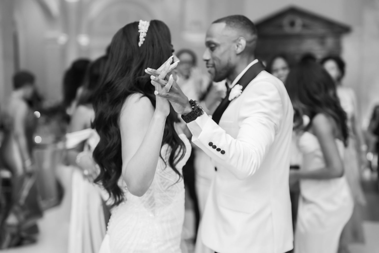 A black and white photo of a couple dancing together at an elegant wedding reception.