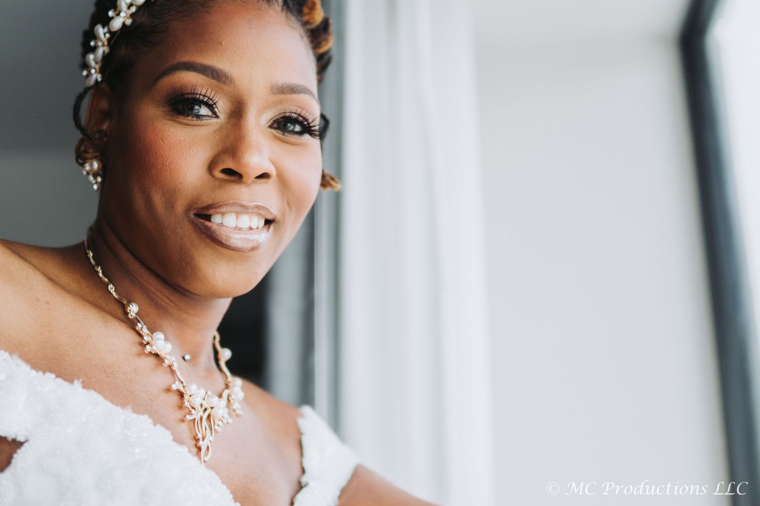 Close-up wedding portrait highlighting bridal jewelry and an elegant off-shoulder gown.