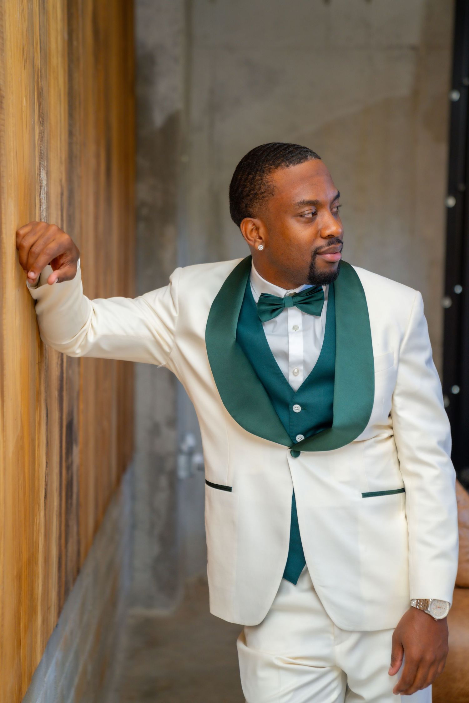 Elegant white tuxedo with emerald green shawl lapel and bow tie creates a sophisticated formal look.