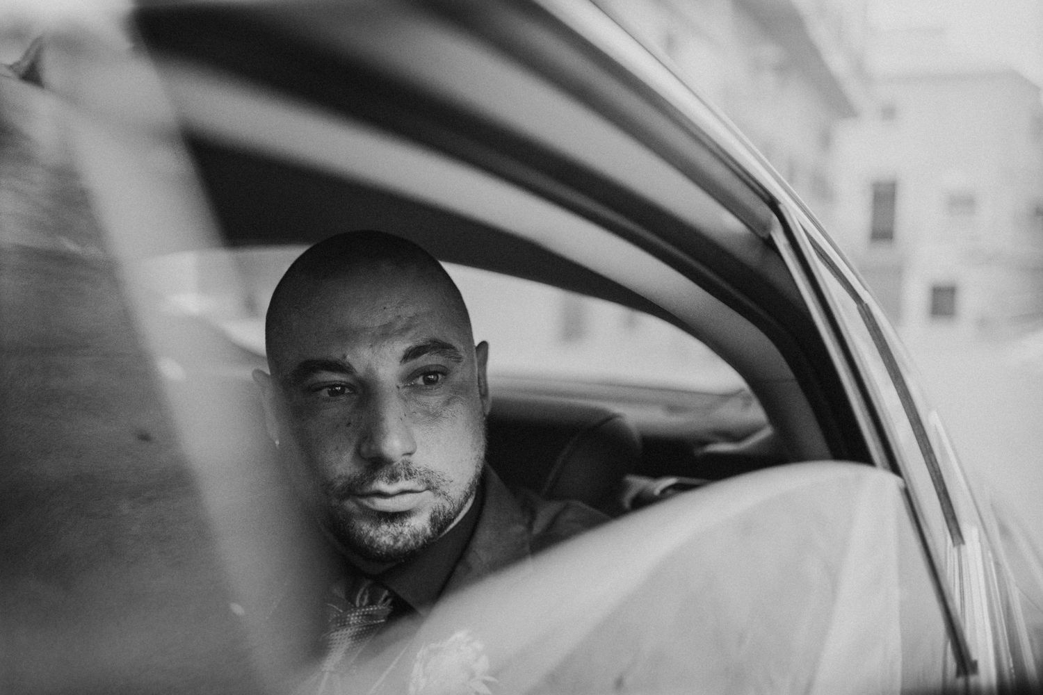 Elegante fotoggrafía del novio dentro del coche que le traslada al lugar de la ceremonia en Aspe. Basílica de Nuestra Señora del Socorro