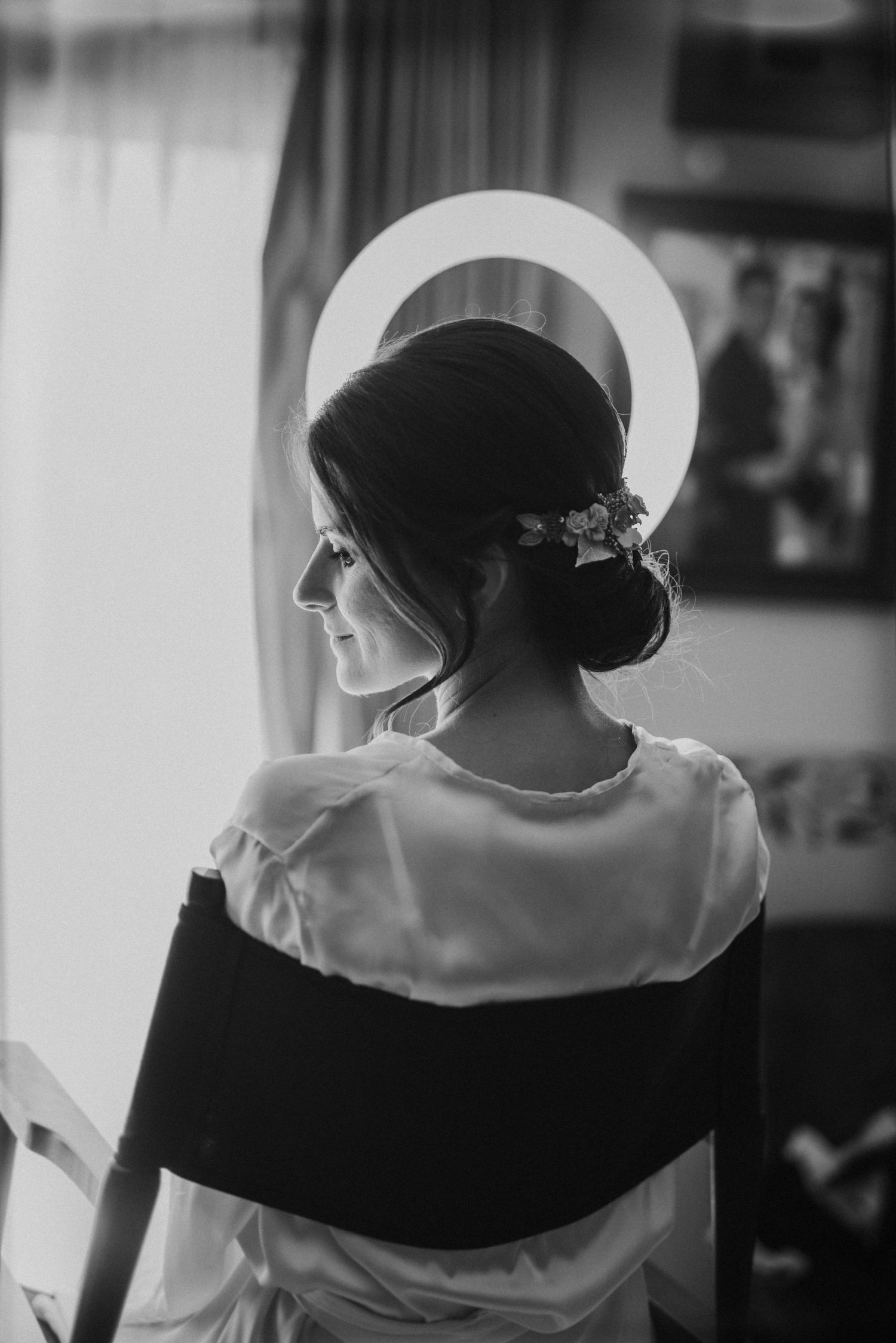 Novia en casa durante los preparativos mientras la preparan para maquillar.