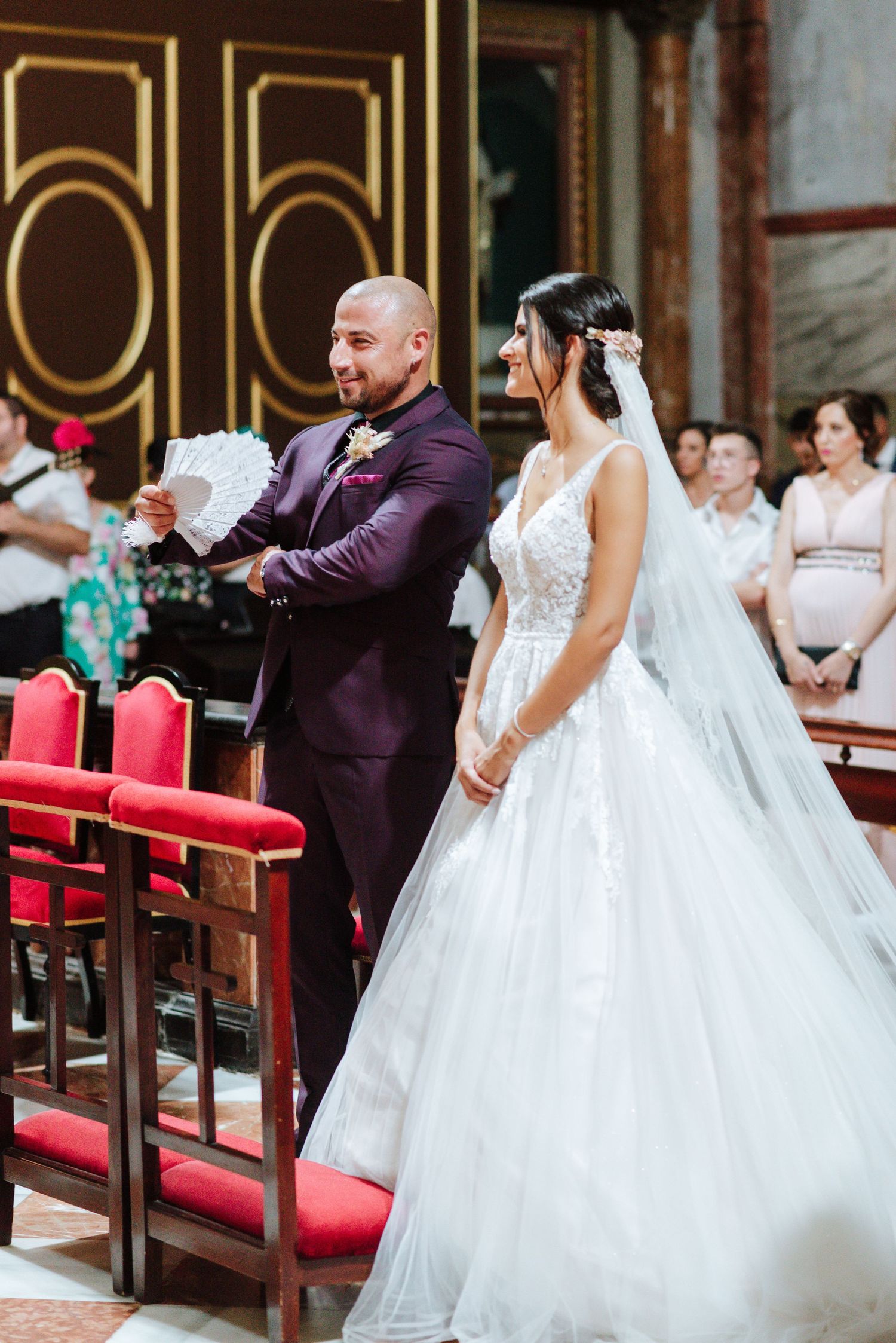 Novia ofrece un abanico al novio durante la ceremonia en Nuestra Señora del Socorro de Aspe, Alicante.