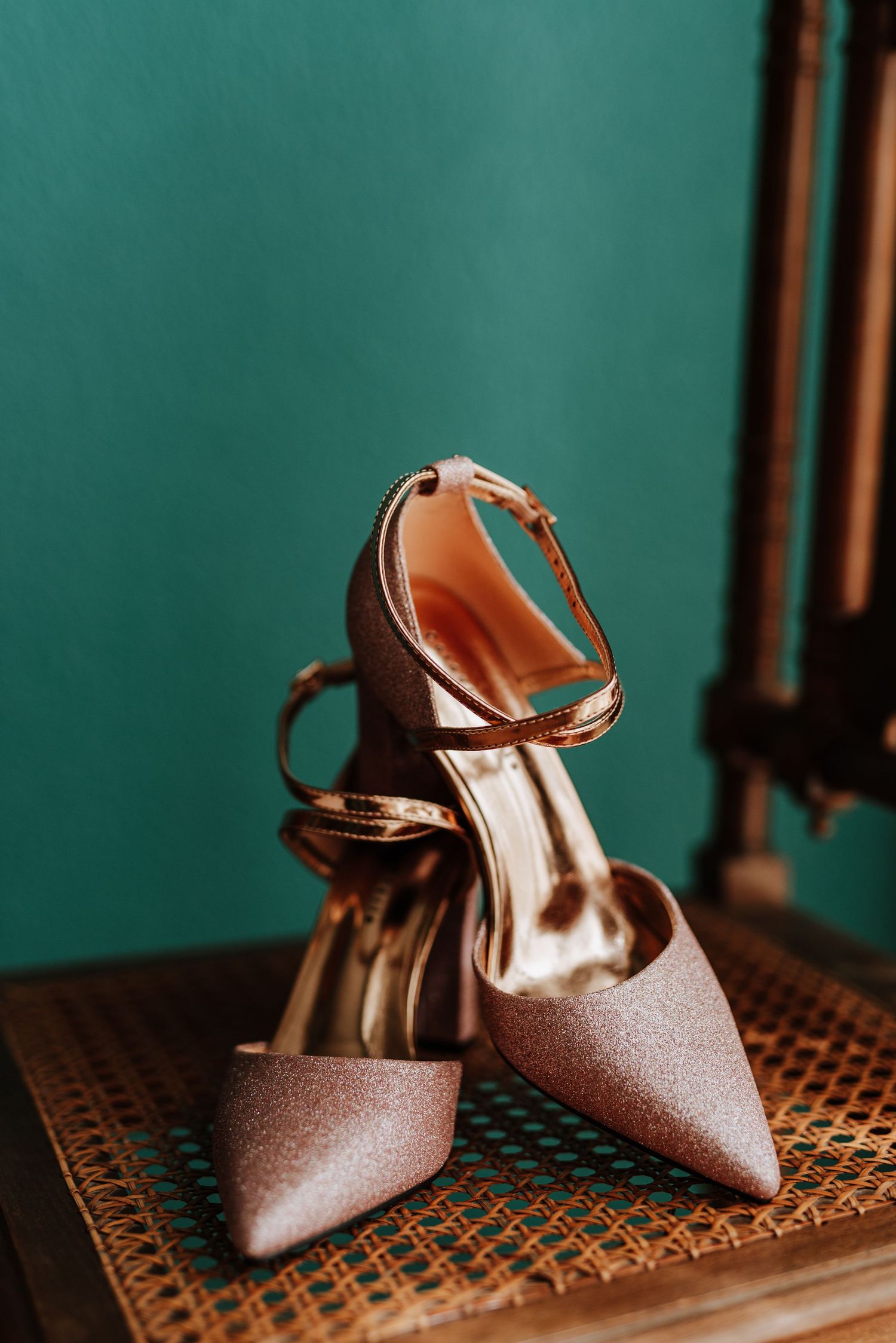 Zapatos de la novia sobre una silla con un fondo de color verde turquesa