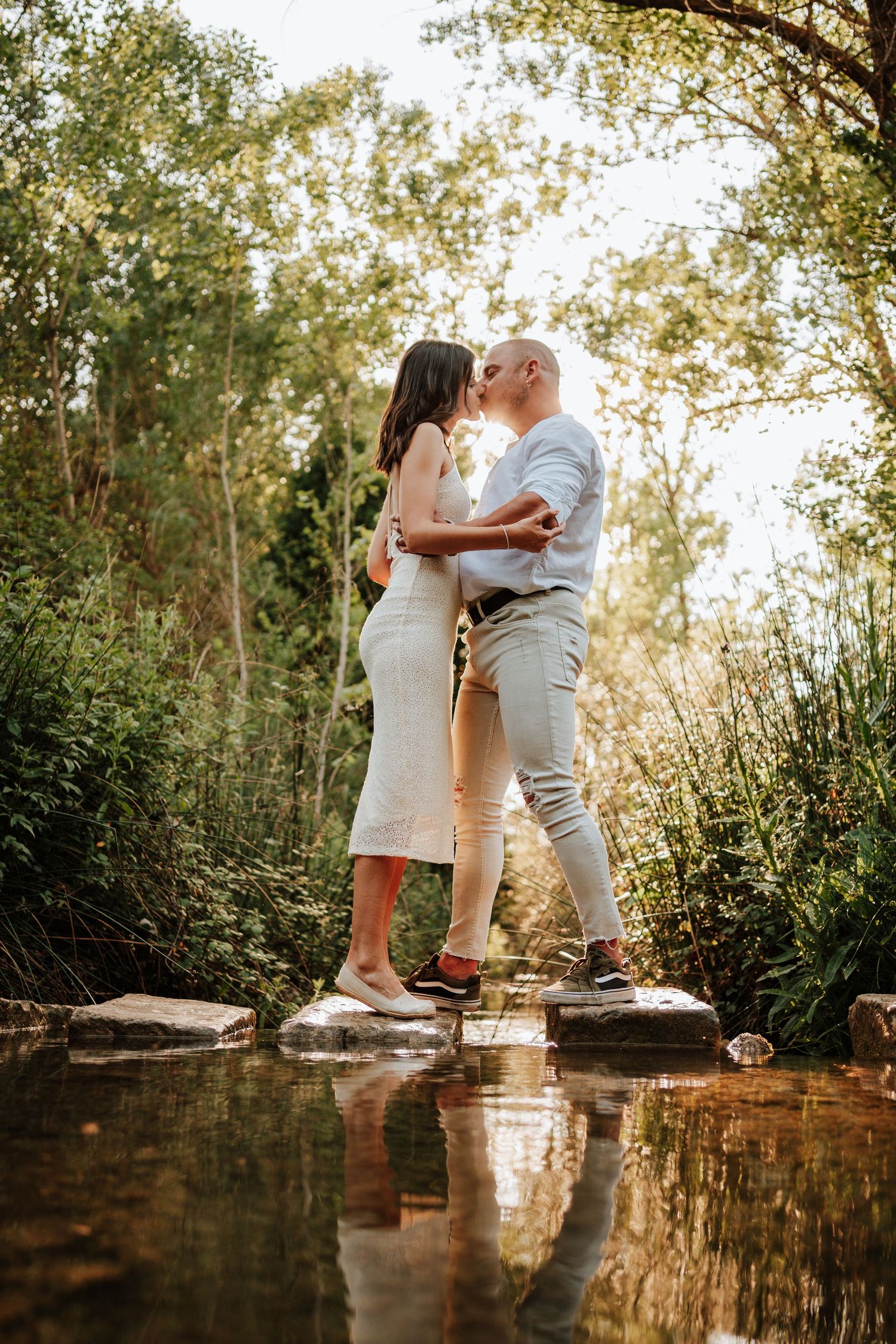 Pareja sobre el reflejo de un río mientras se besan apasionadamente en Banyeres de Mariola, Alicante