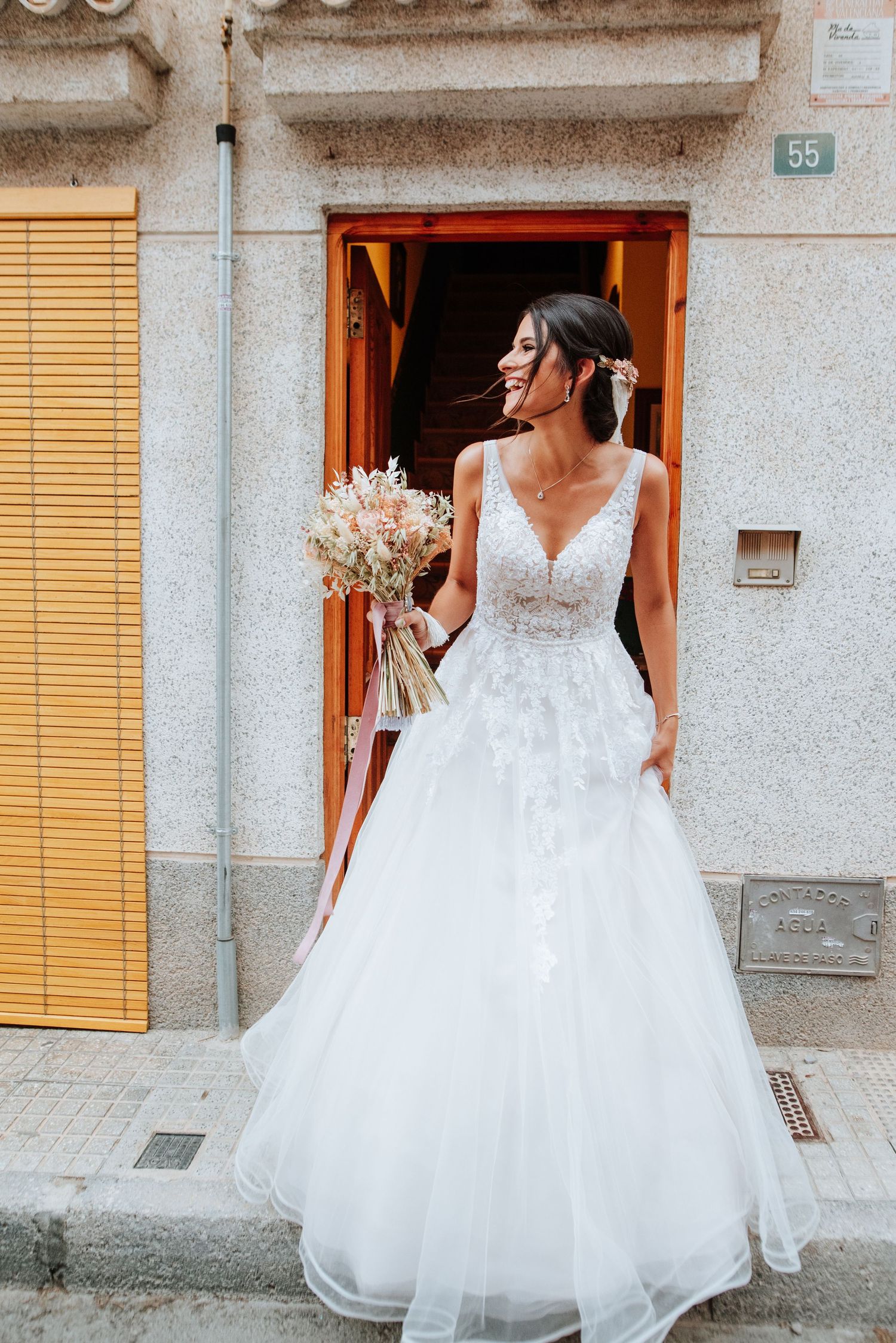 Escena rural y costumbrista en el que la novia sale a la calle desde la casa de sus padres durante una boda en Aspe, Alicante