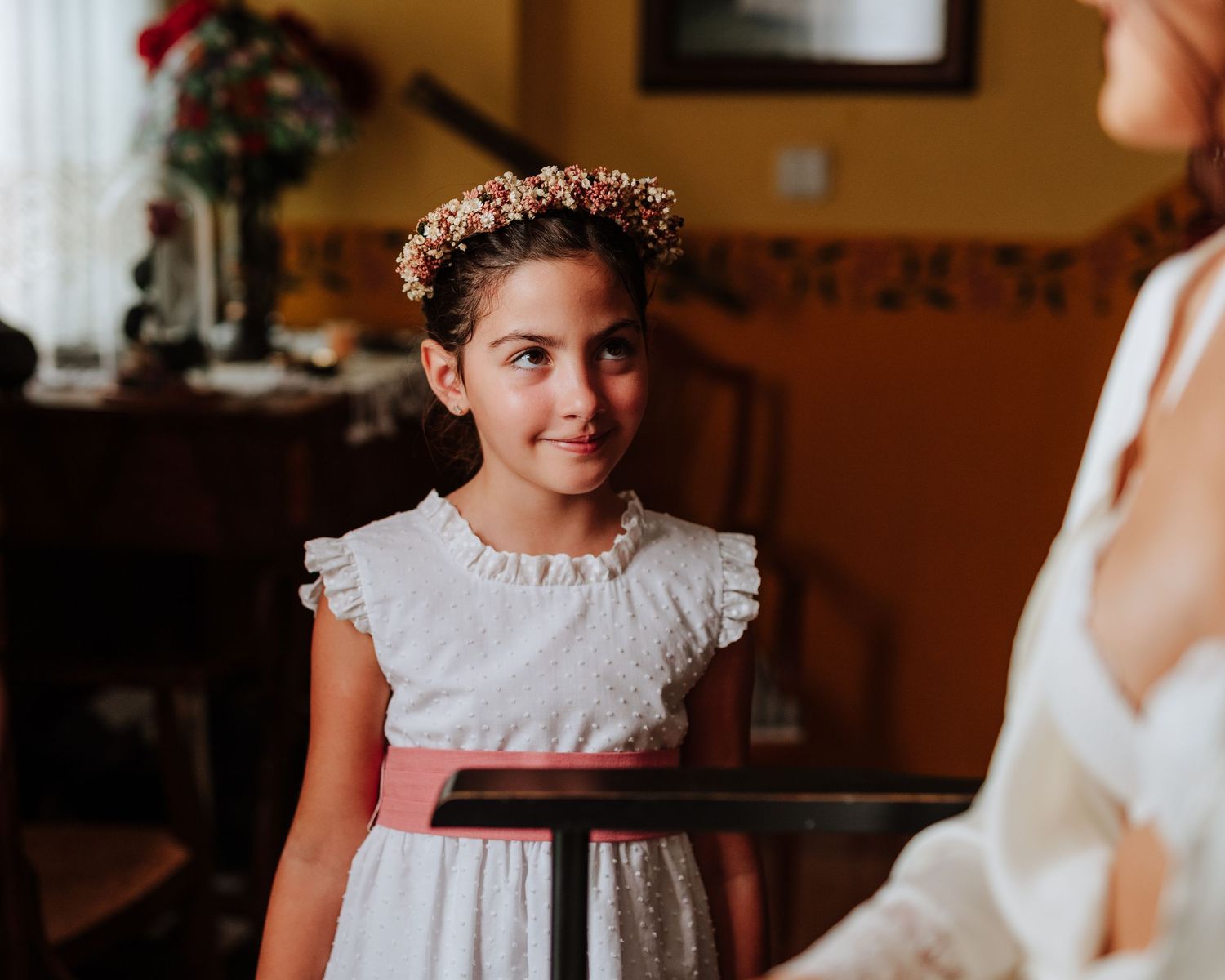 Niña con diadema mira a la novia durante los preparativos