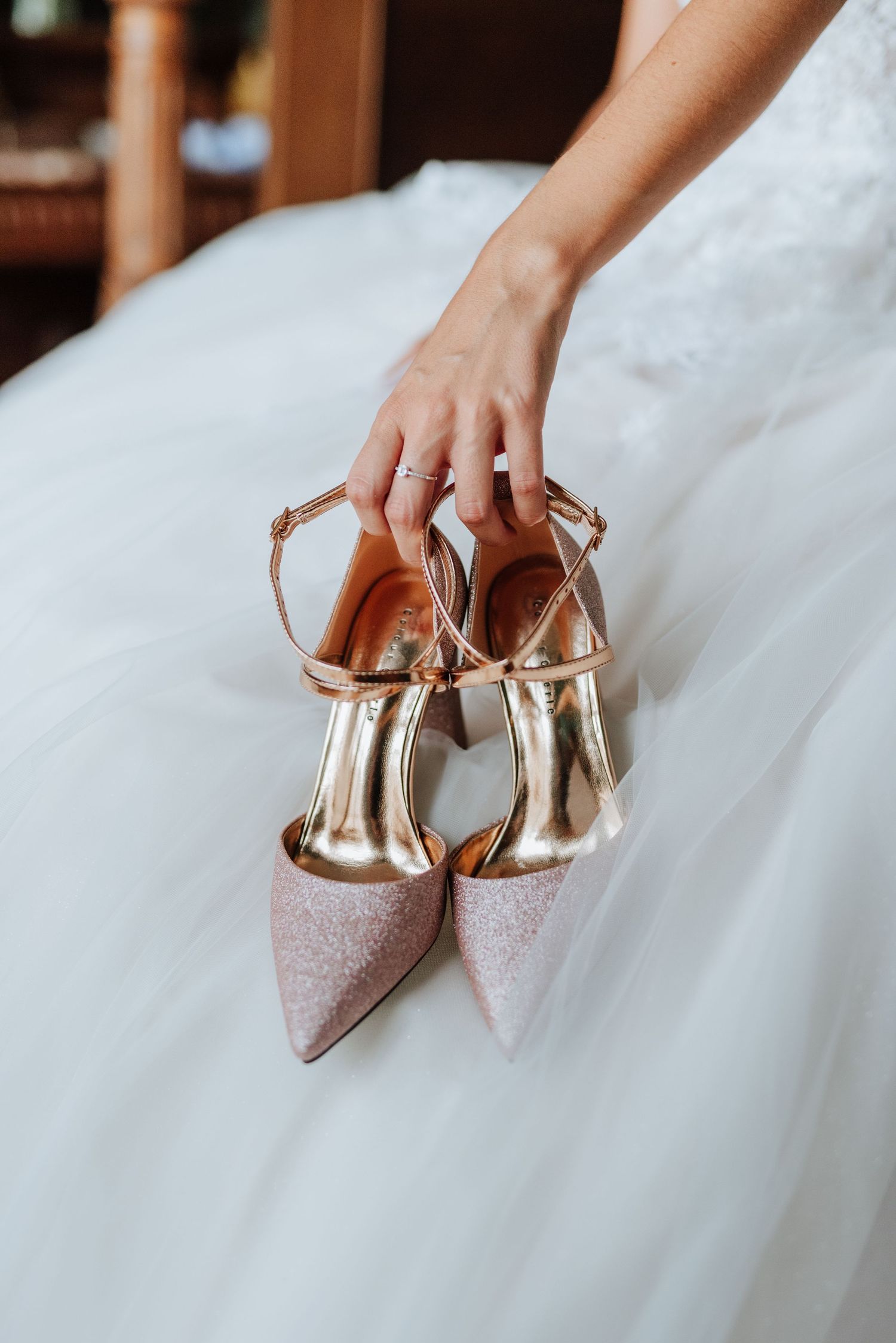 Detalle de la mano de la novia sosteniendo sus zapatos de boda.