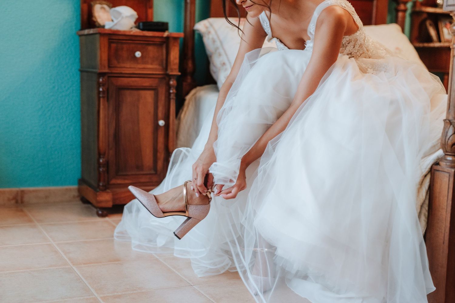 Novia se acomoda los zapatos en el día de su boda.