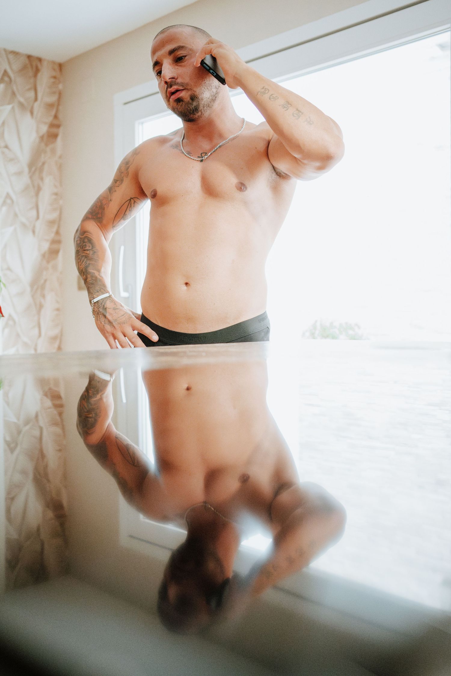 Novio sin camiseta habla por teléfono