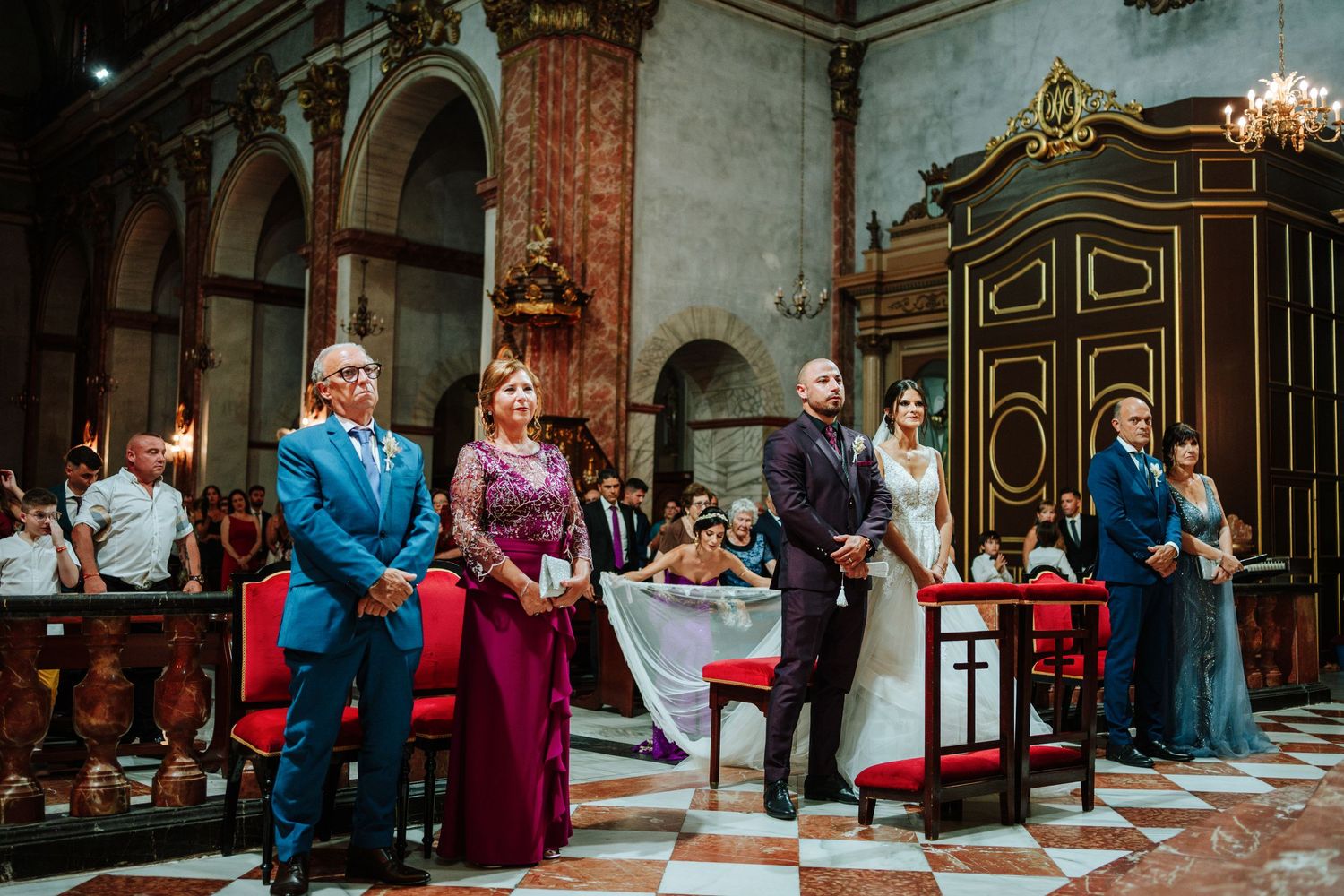 Novios y padrinos en Basílica de Nuestra Señora del Socorro de Aspe, Alicante. Mientras la hermana de la novia acomoda su vestido.