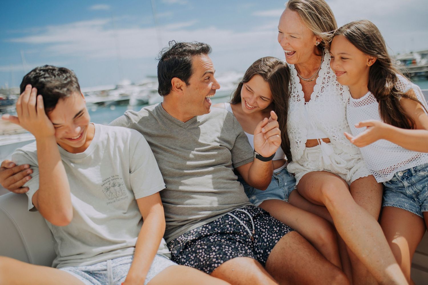 Family sharing joyful laughter together while relaxing outdoors on a sunny day.