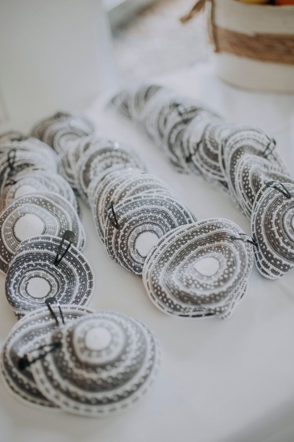 Black and white circular patterned paper fans arranged in rows on a white table surface.