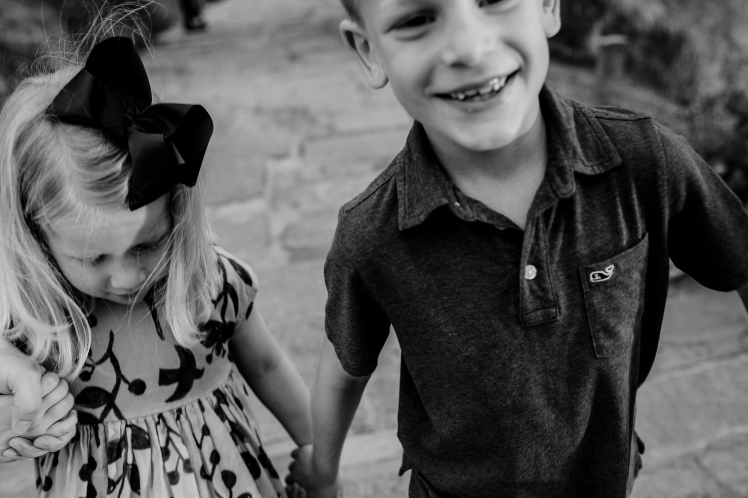 A playful black and white portrait of two children laughing together.