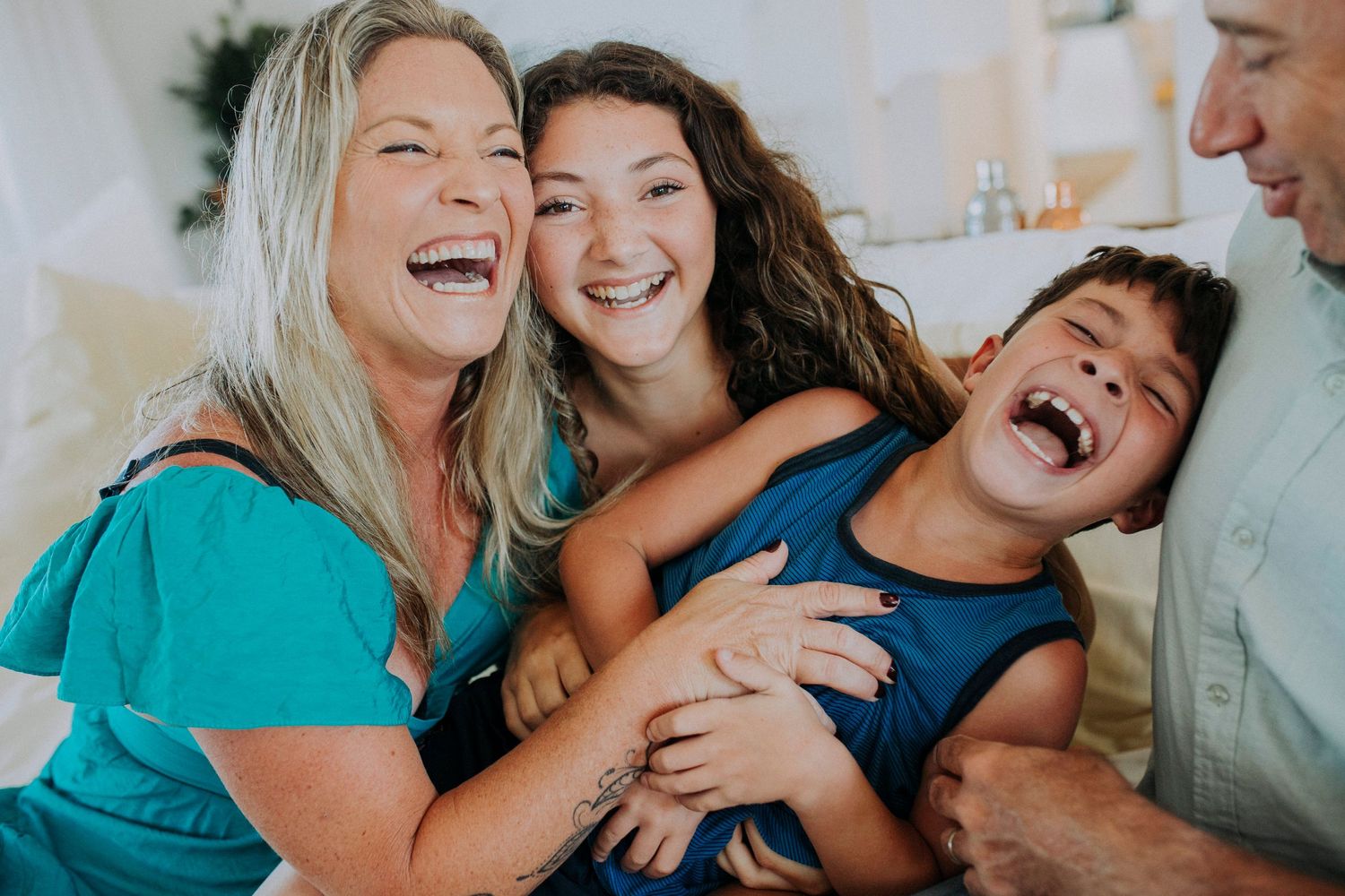 A candid moment of joyful laughter shared between family members in a bright indoor setting.