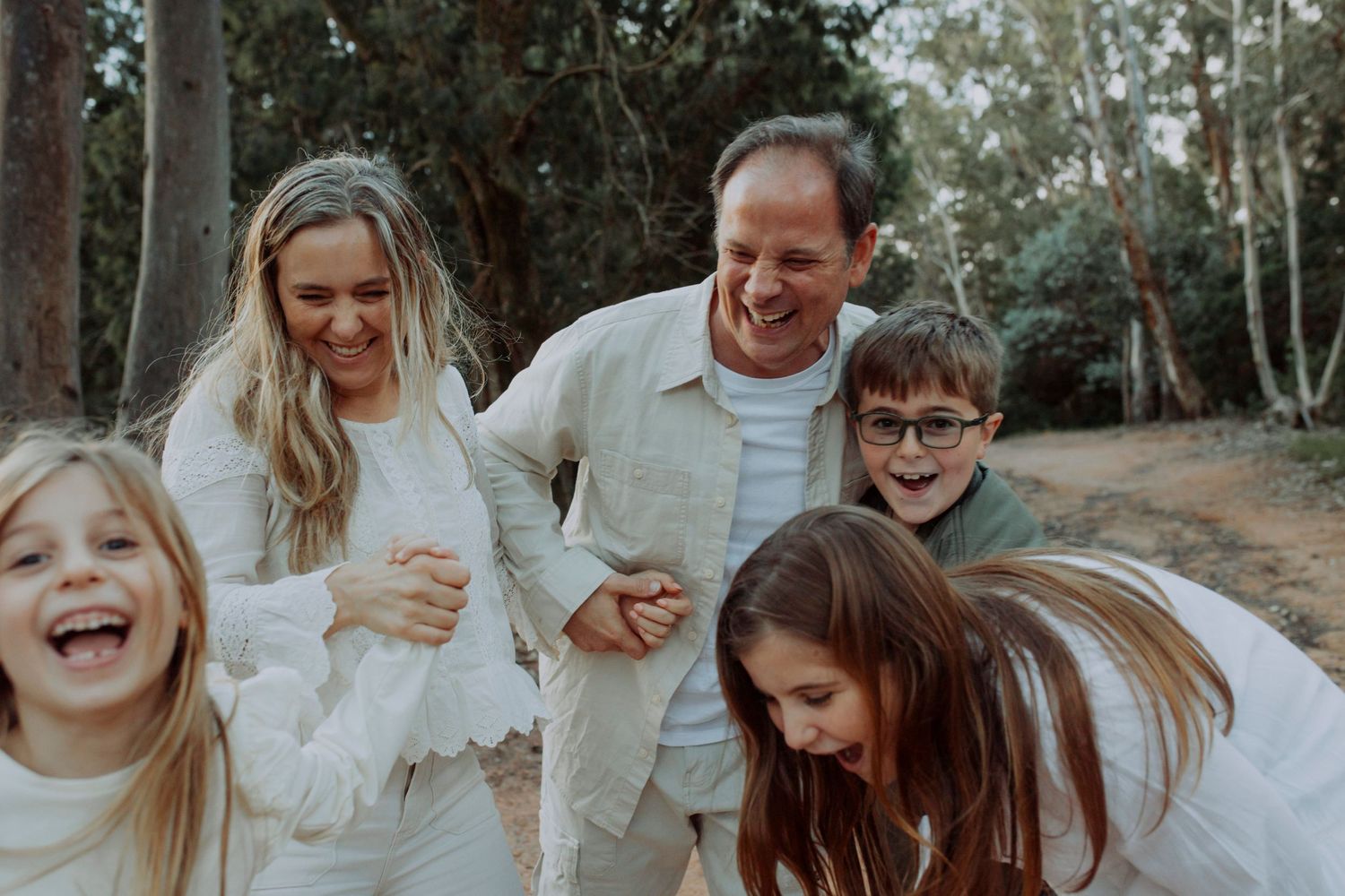 A lighthearted family moment captured outdoors with everyone laughing together.