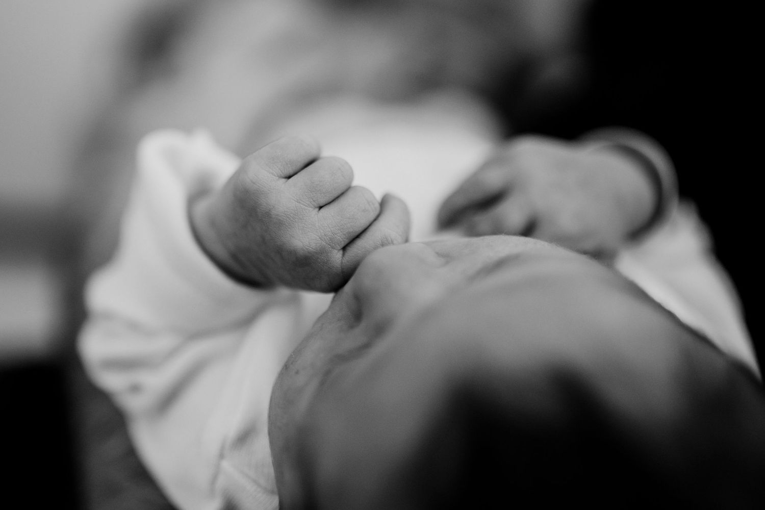 Close-up black and white portrait of a sleeping newborn baby's peaceful face.