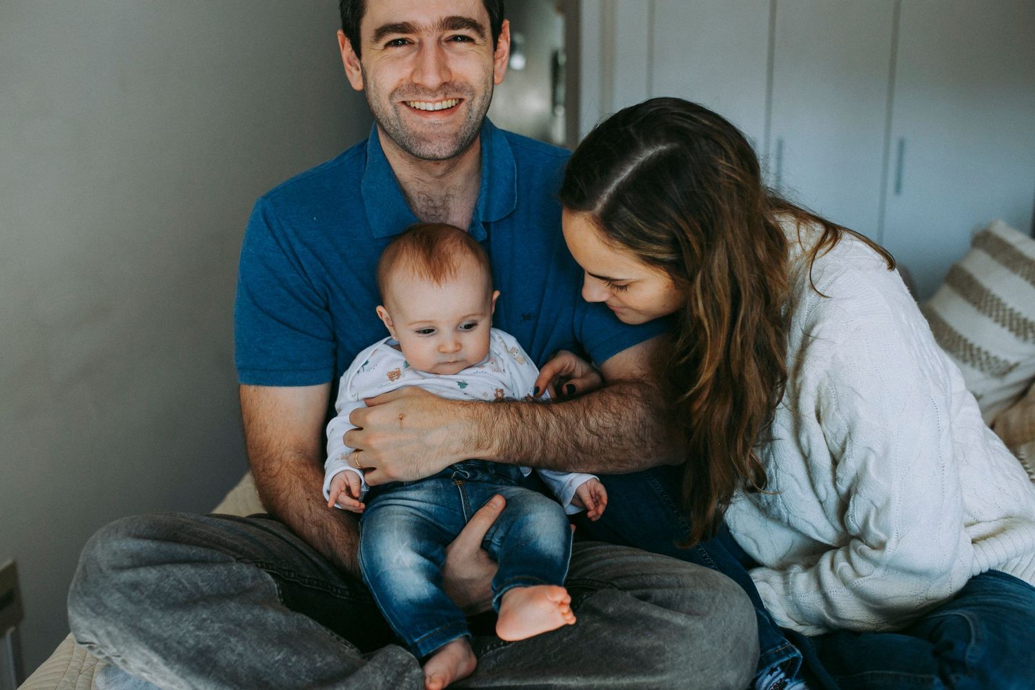 A tender family moment with a baby in casual home setting.