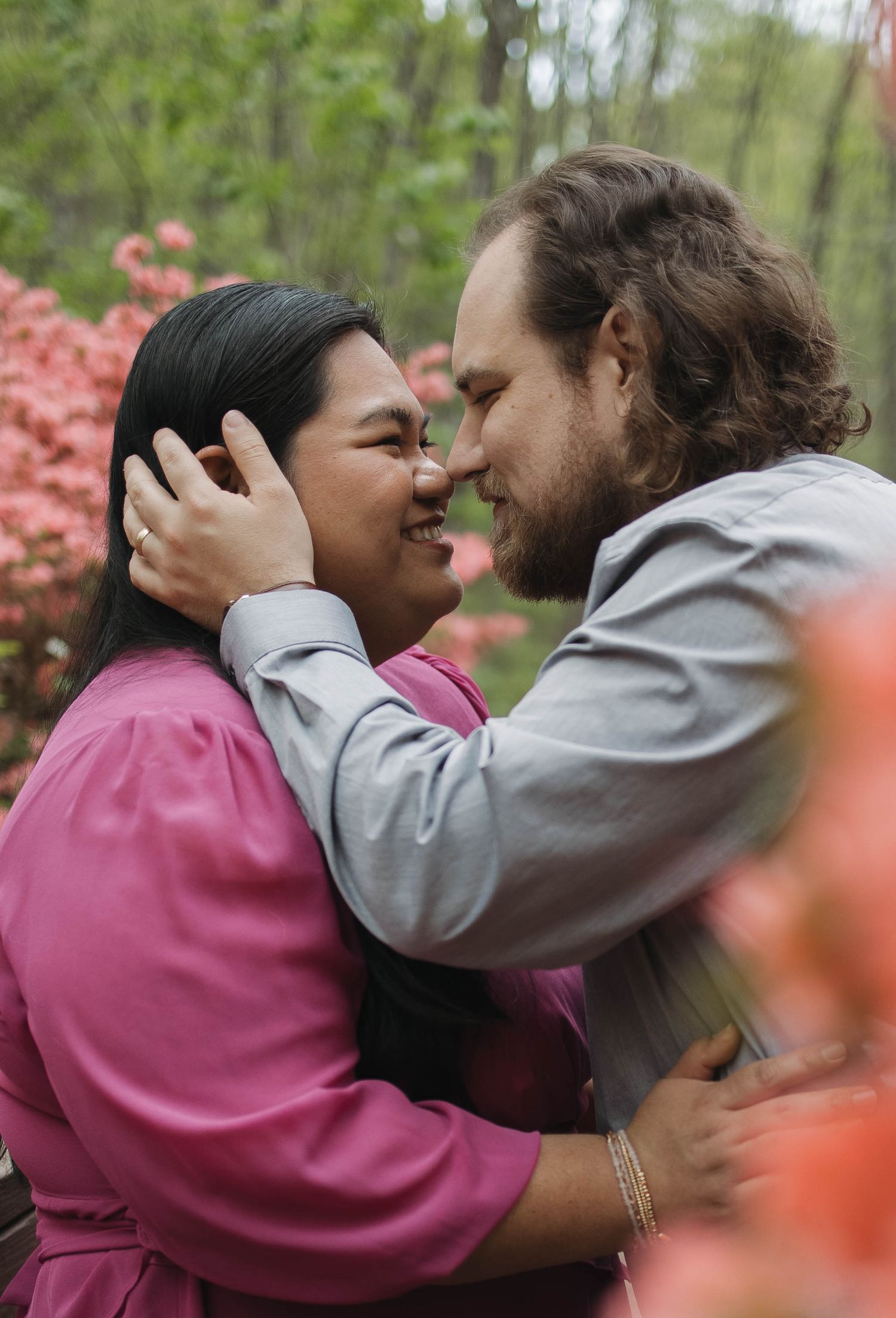 A romantic embrace among blooming pink flowers in springtime.