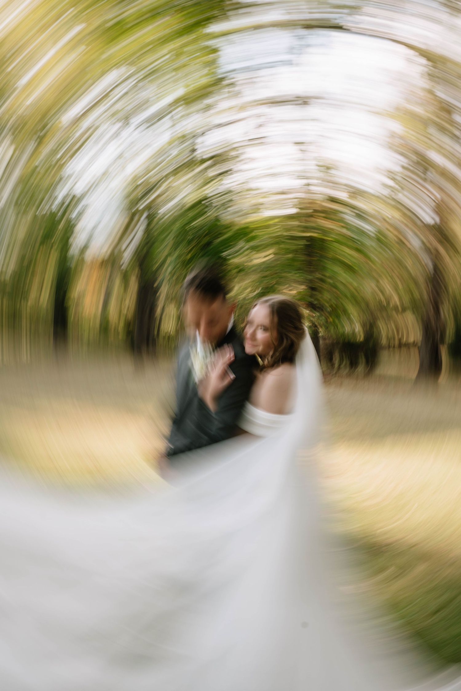Motion blur abstract sequence of two people dancing in a garden setting with palm trees in the background.