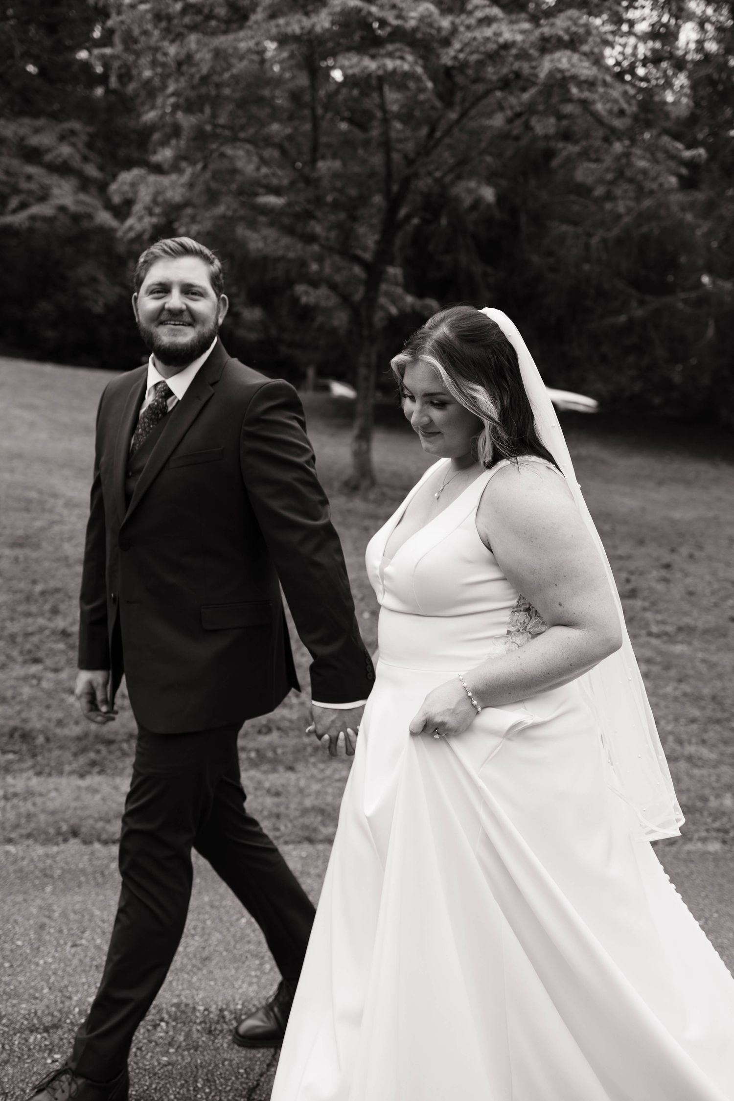 Black and white wedding photos capturing couple's playful interactions outdoors.