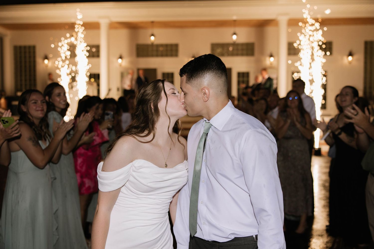 Sparklers light up the dance floor as couples dance during a wedding reception.