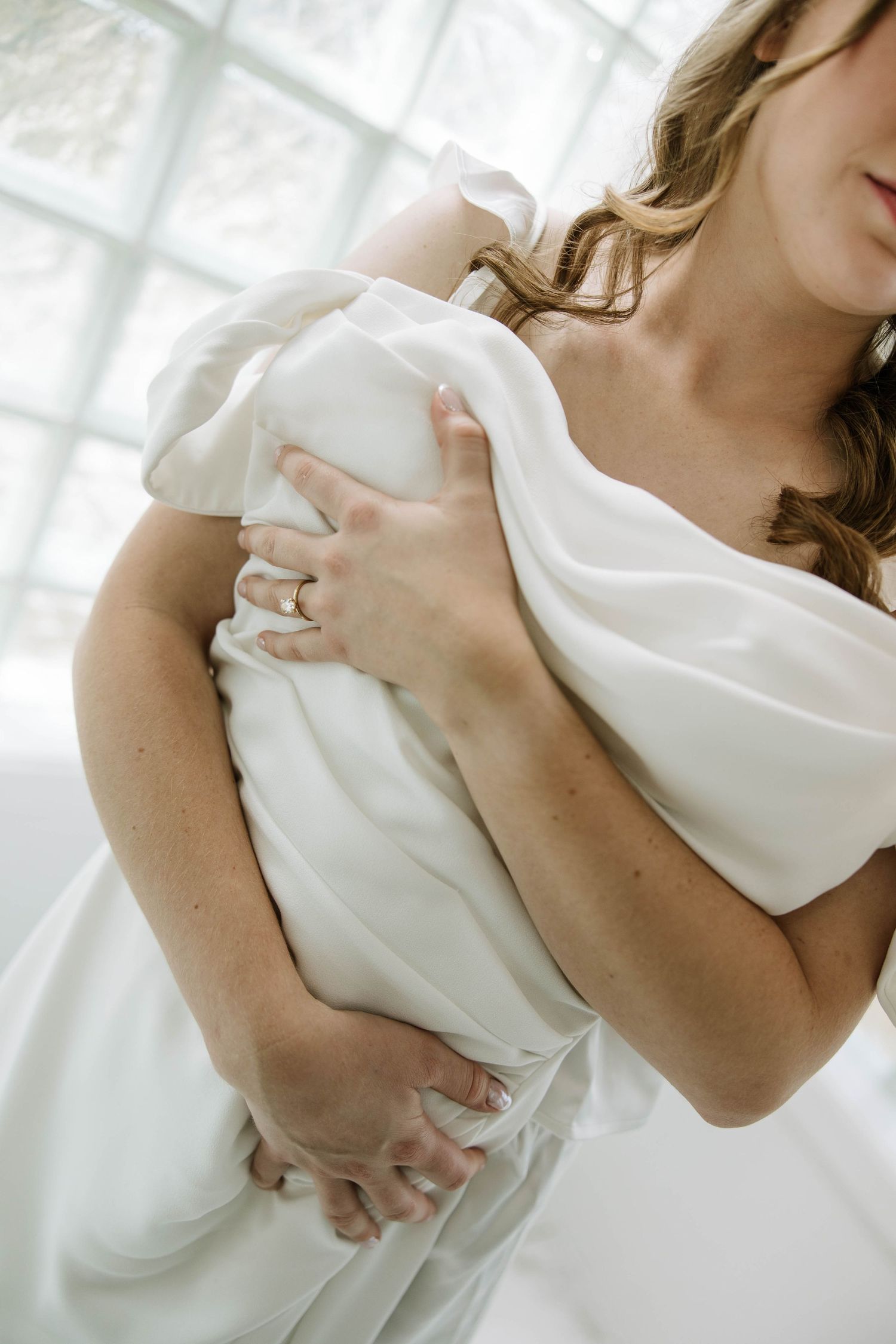 Artistic close-up shots of a white wedding dress with flowing fabric details and elegant draping.