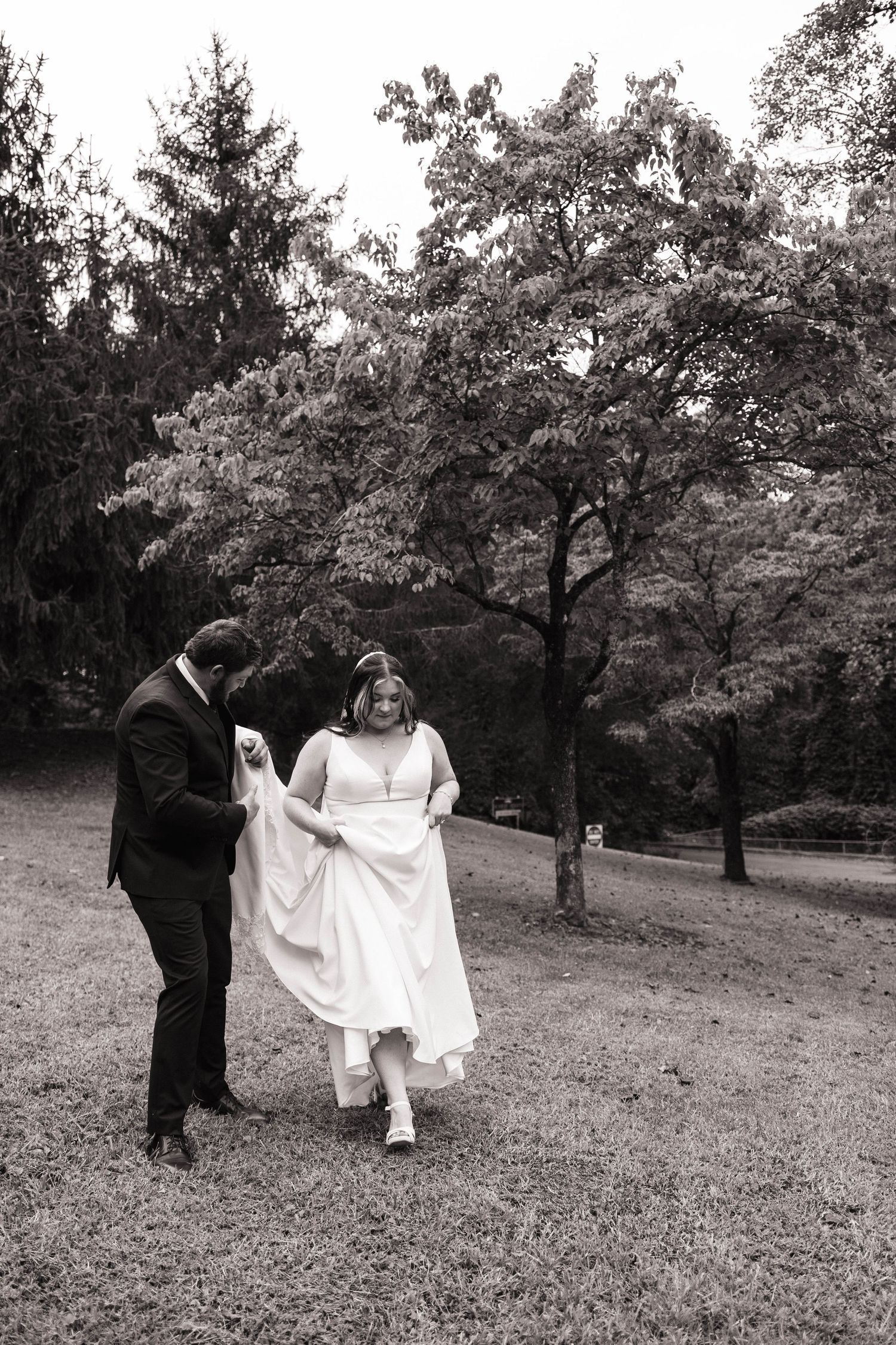 Monochrome wedding photos showing couple dancing in a scenic park setting.