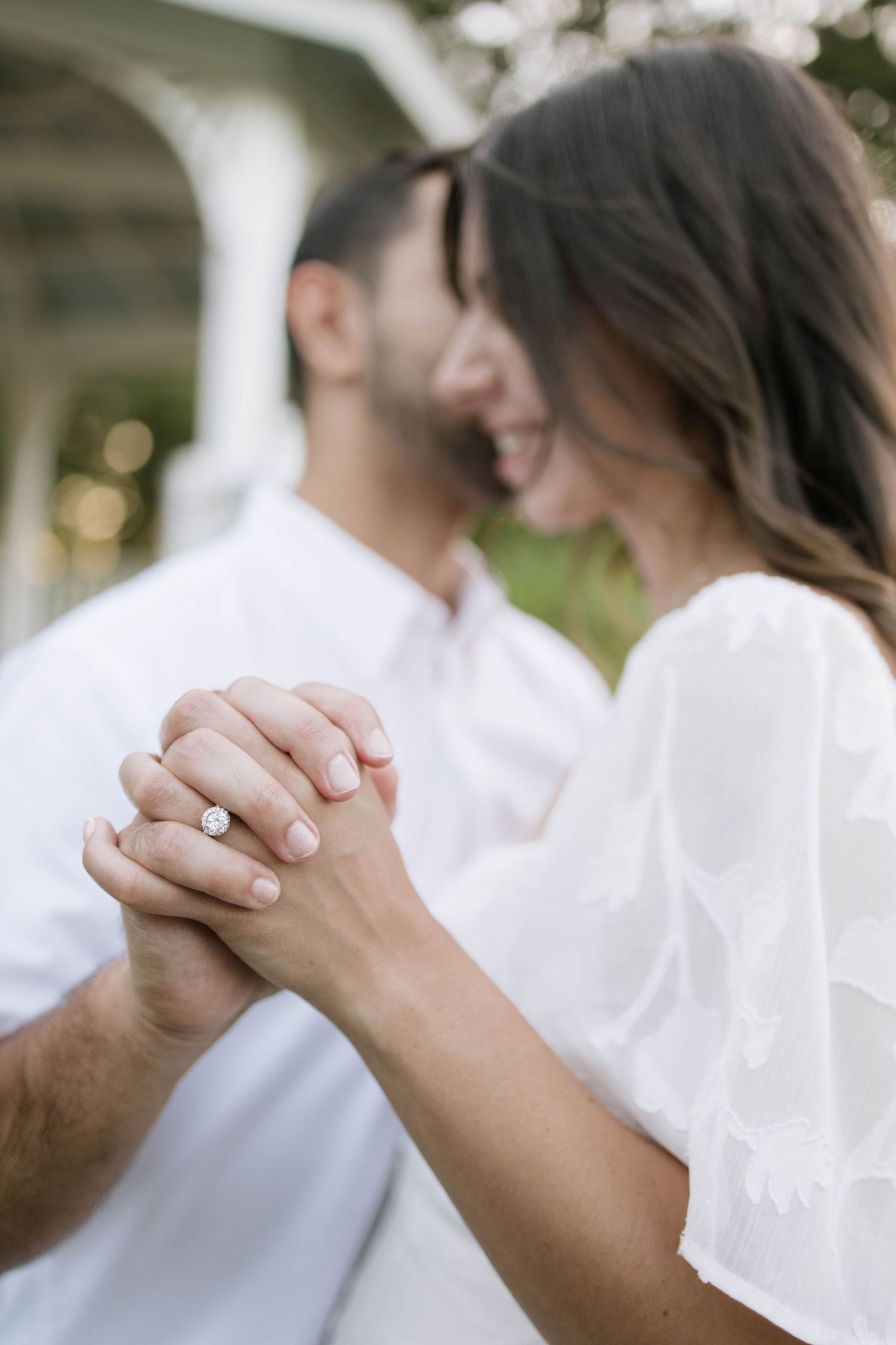 Close-up of hands clasped together showing intimate connection during engagement session.