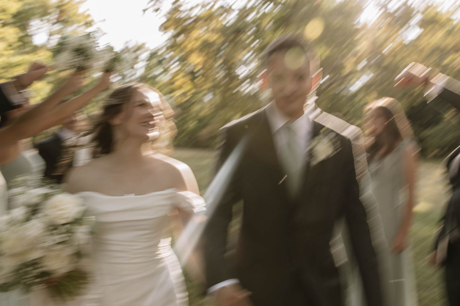 Motion-blurred wedding celebration photo in outdoor garden setting.