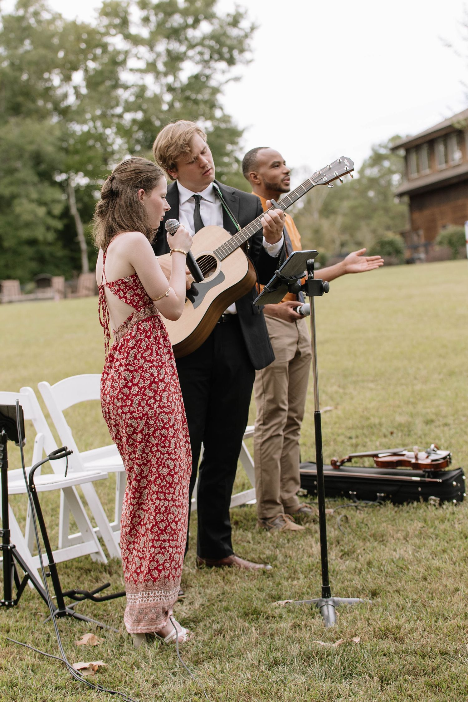 Musicians performing with guitars during outdoor wedding celebration.