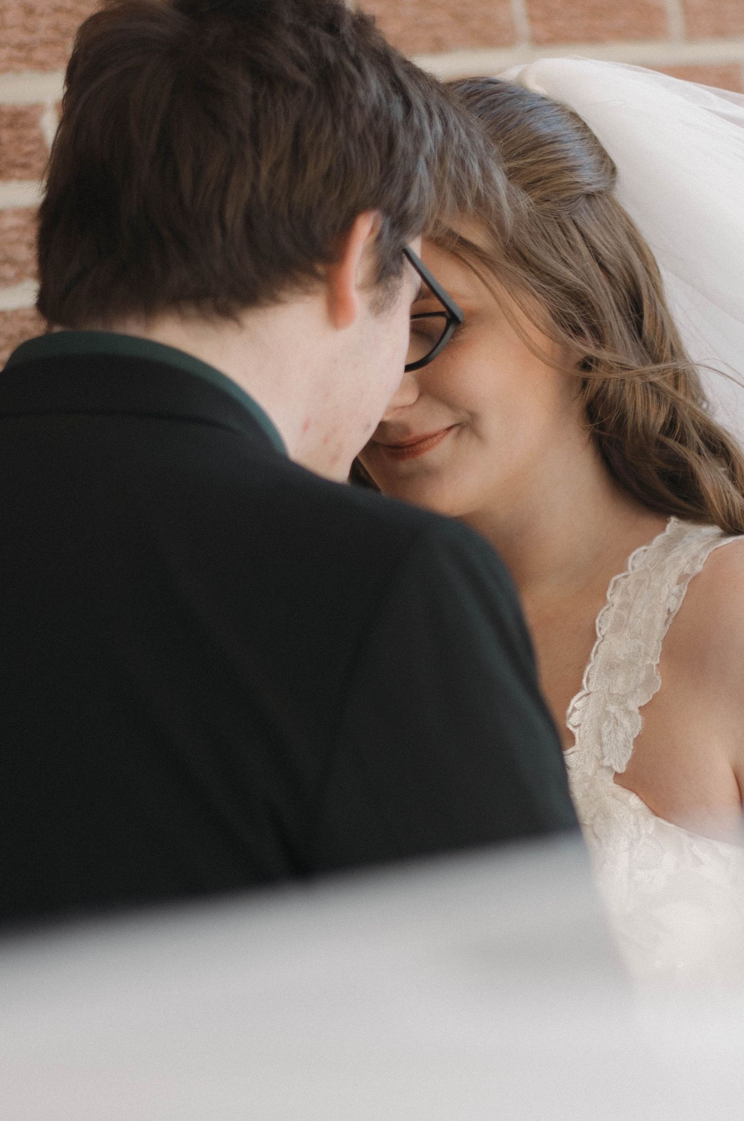 An intimate close-up moment shared between a couple in wedding attire.