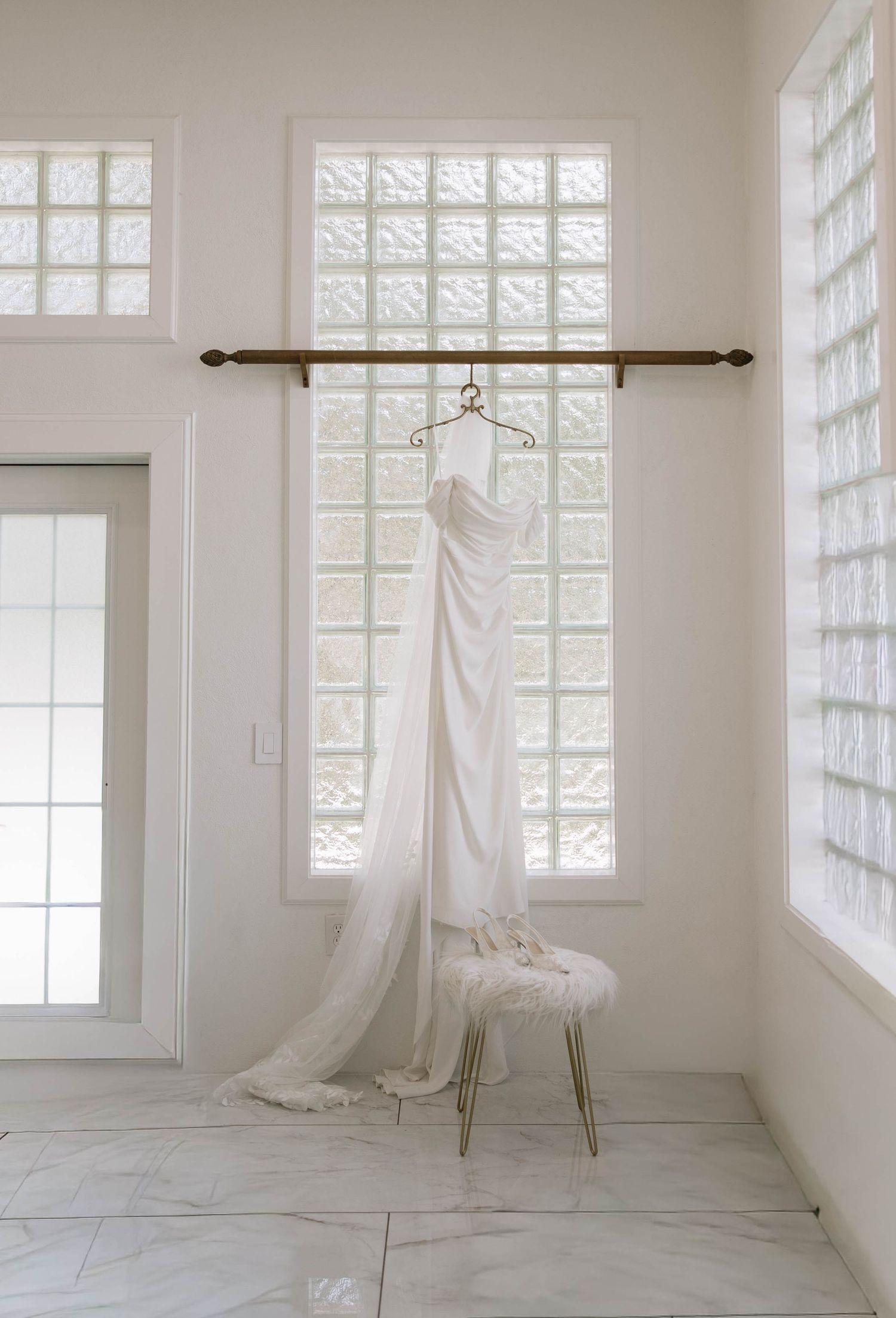 Four sequential photos show a flowing white dress suspended from a clothing rack in a bright, minimalist room with gridded windows.