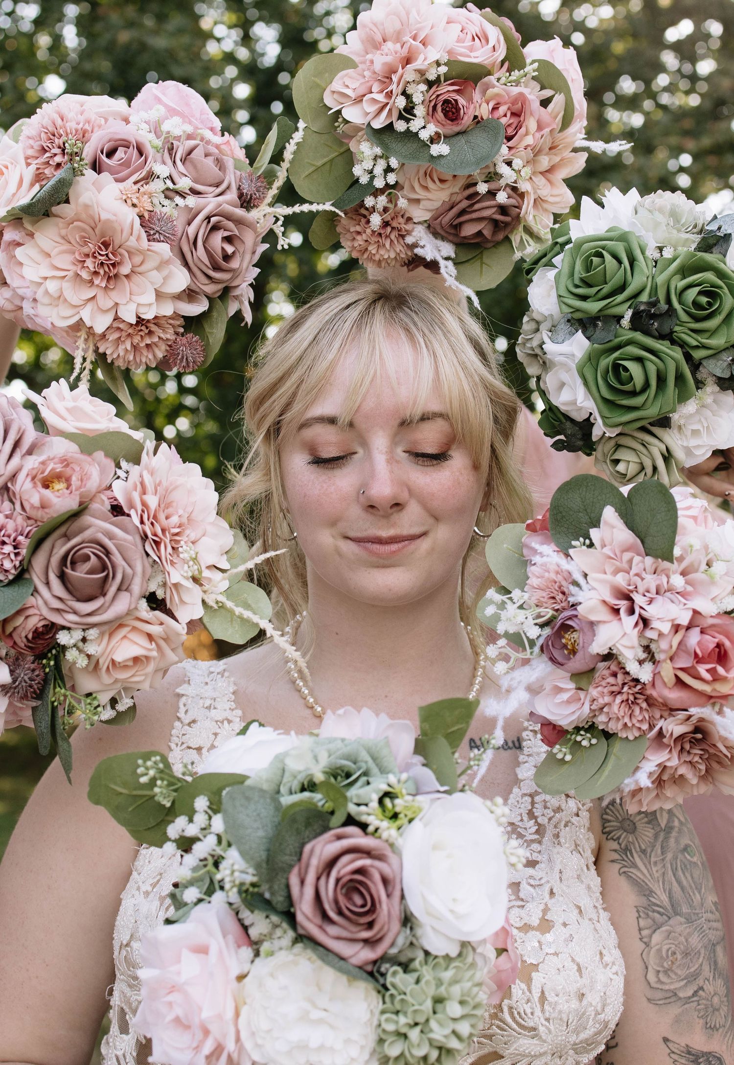 A bridal portrait featuring a floral crown made of pink roses and greenery against a natural backdrop.
