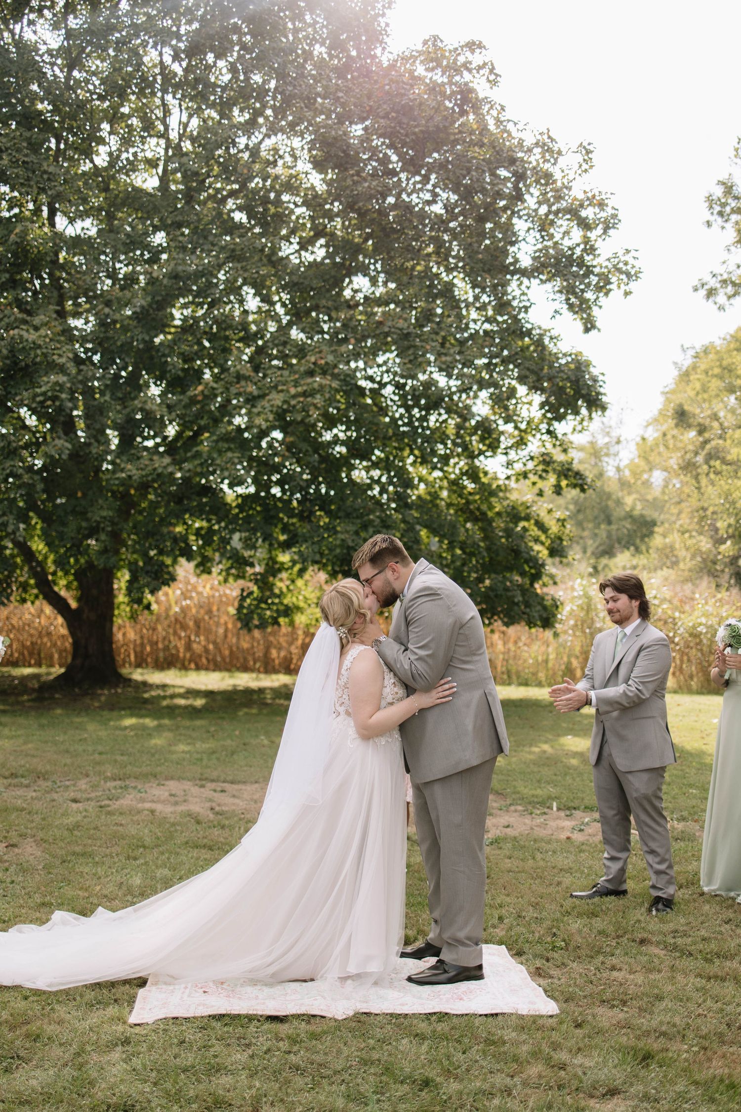 An intimate outdoor wedding ceremony moment captured under a large tree.