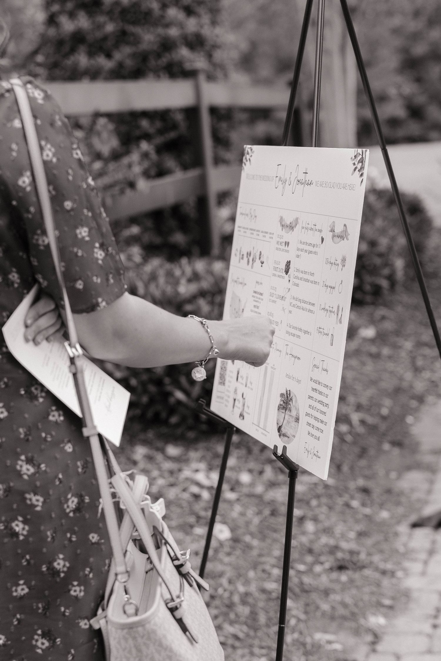 Black and white photo of wedding timeline and schedule cards hanging on display.
