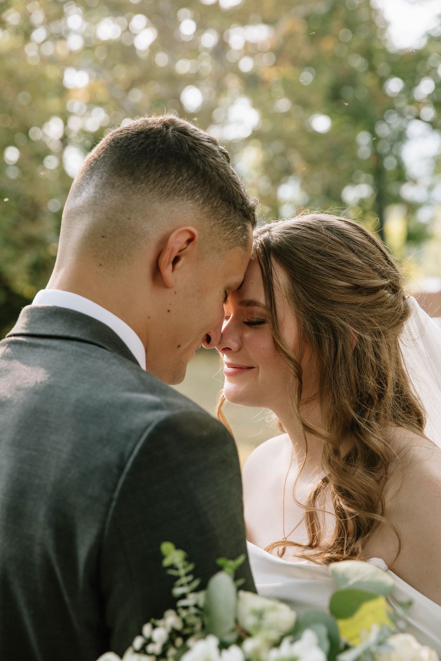 A romantic wedding couple shares intimate kisses in a series of outdoor portraits with natural lighting.