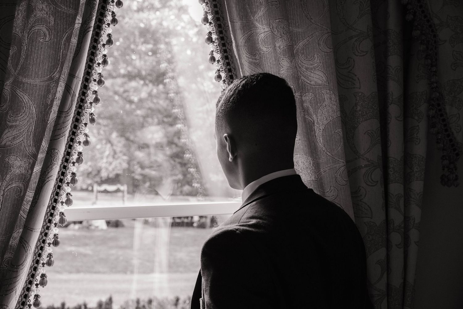 Dramatic black and white silhouette through curtained window.