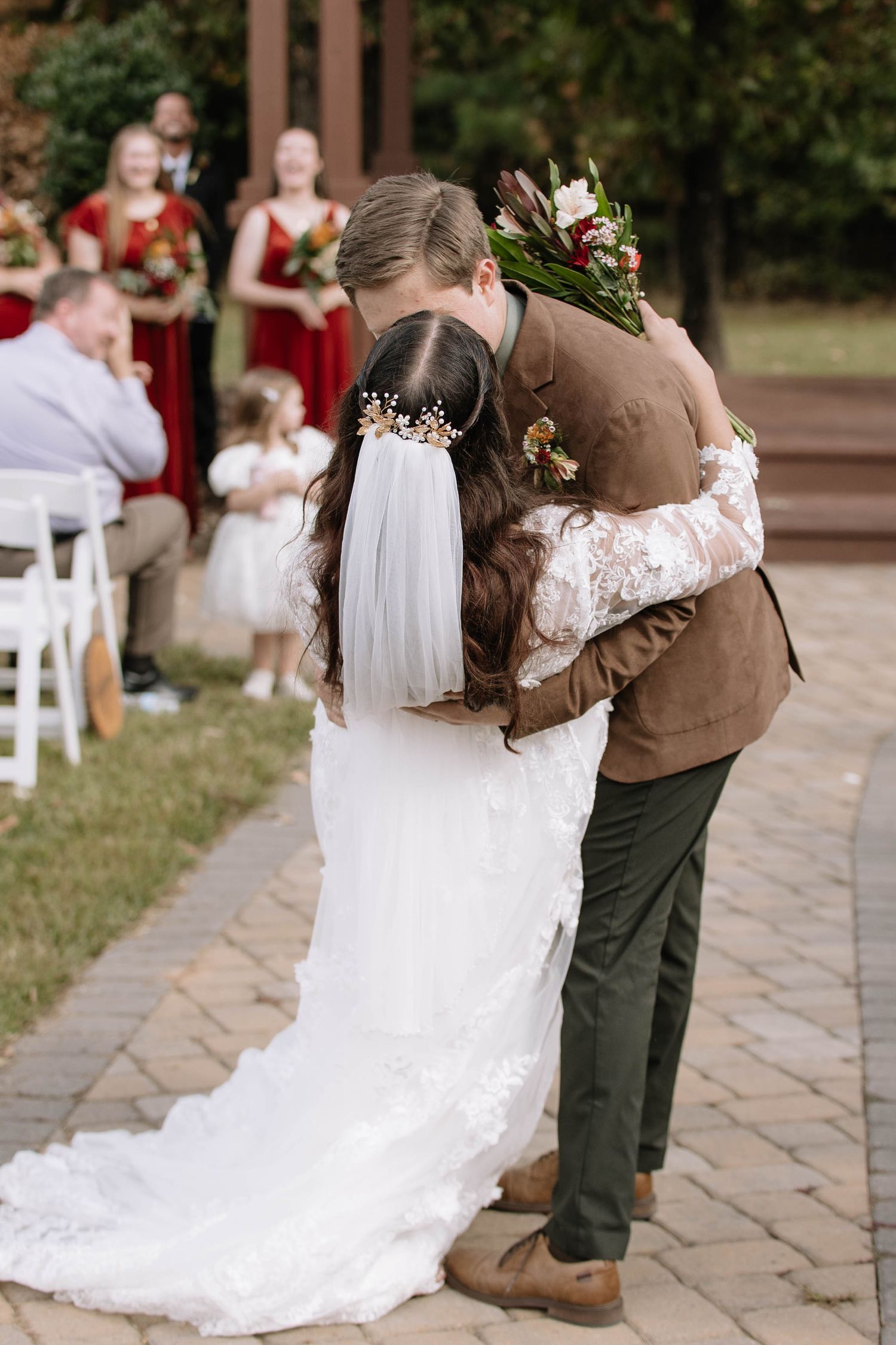 Couple shares first dance on stone patio during outdoor wedding reception.