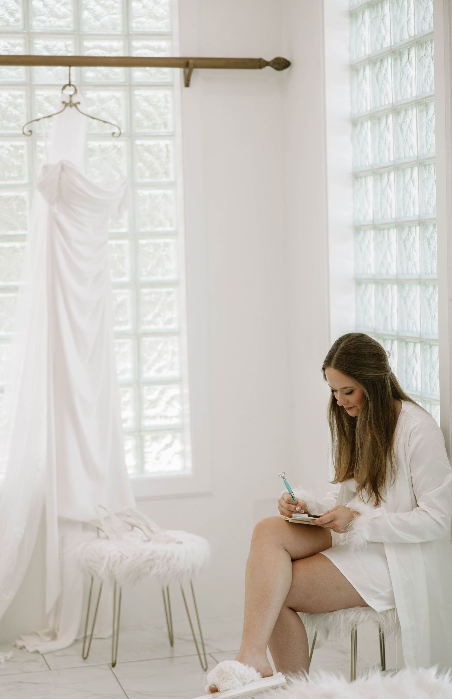 Bridal preparation in bright white room with natural window light.