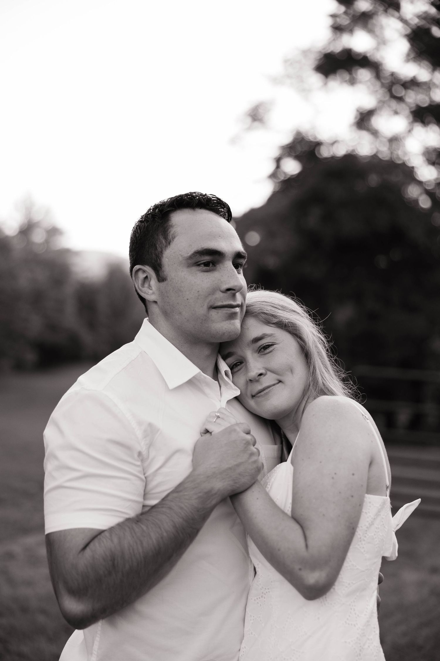 Black and white portraits of a couple sharing intimate moments in a field.