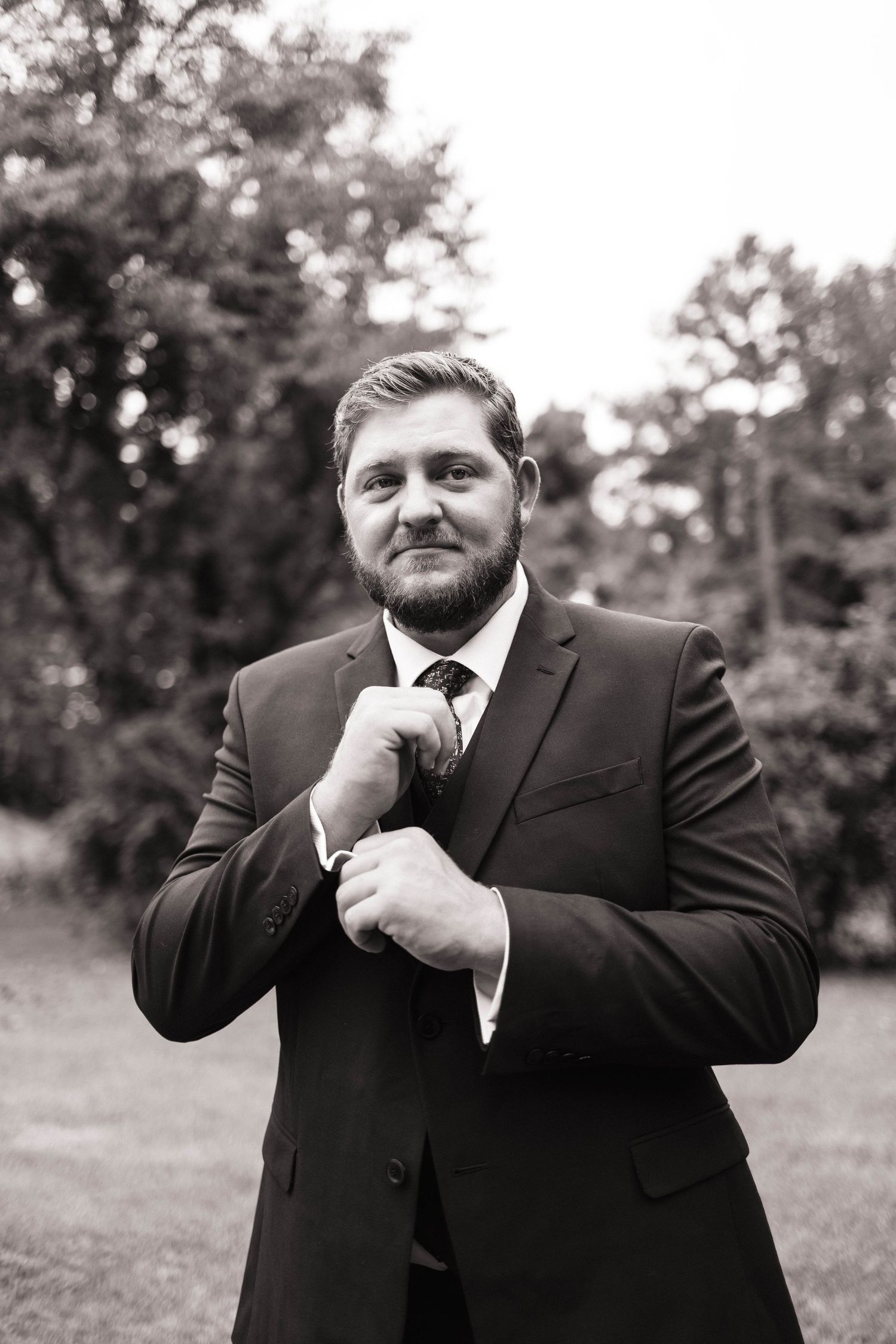Series of black and white portraits showing groom adjusting his tie before the ceremony.