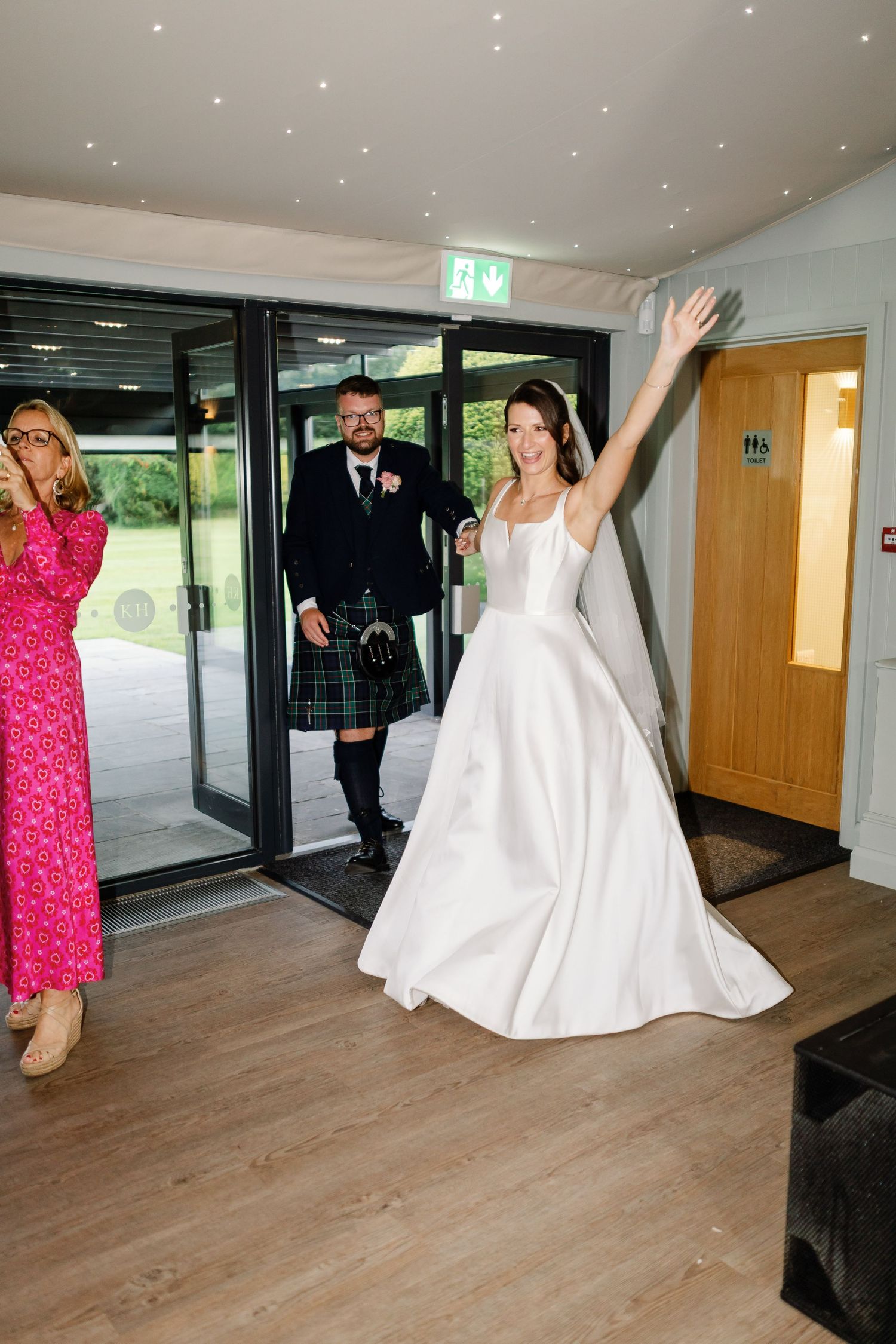 A series of wedding photos showing a bride in a white gown and guests in formal attire walking through a modern indoor venue.